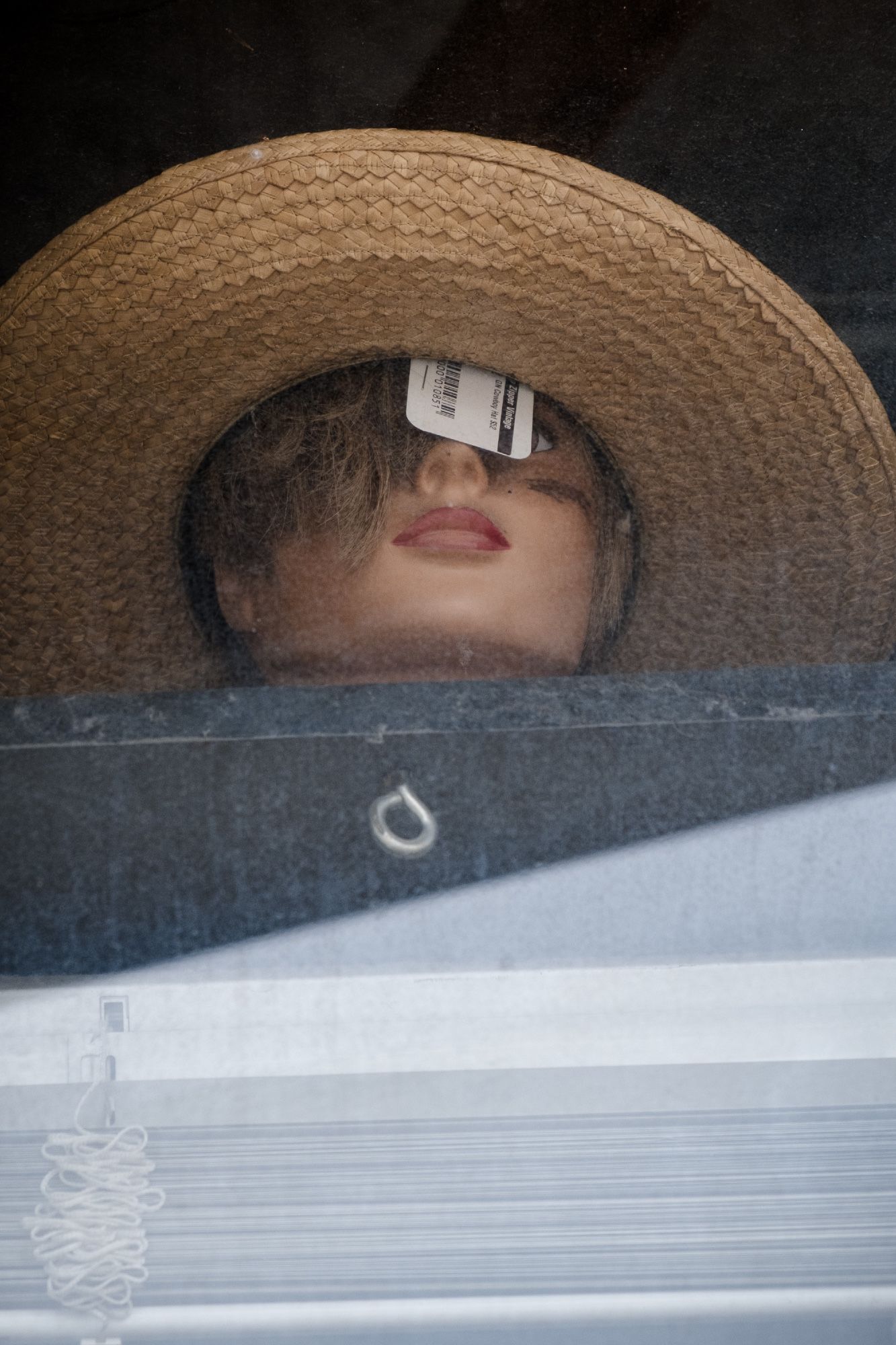 A mannequin looks out onto the East Nashville streets as best she can considering she has a price tag obstructing her view.