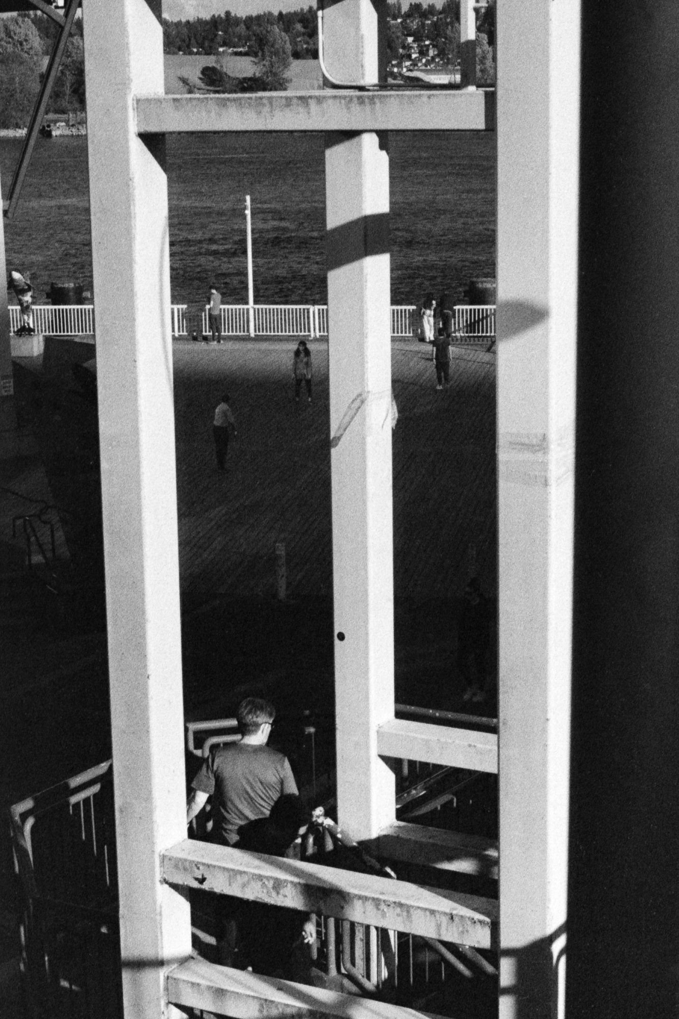 People out on an evening walk by the river become consumed by shadows from neighbouring buildings.