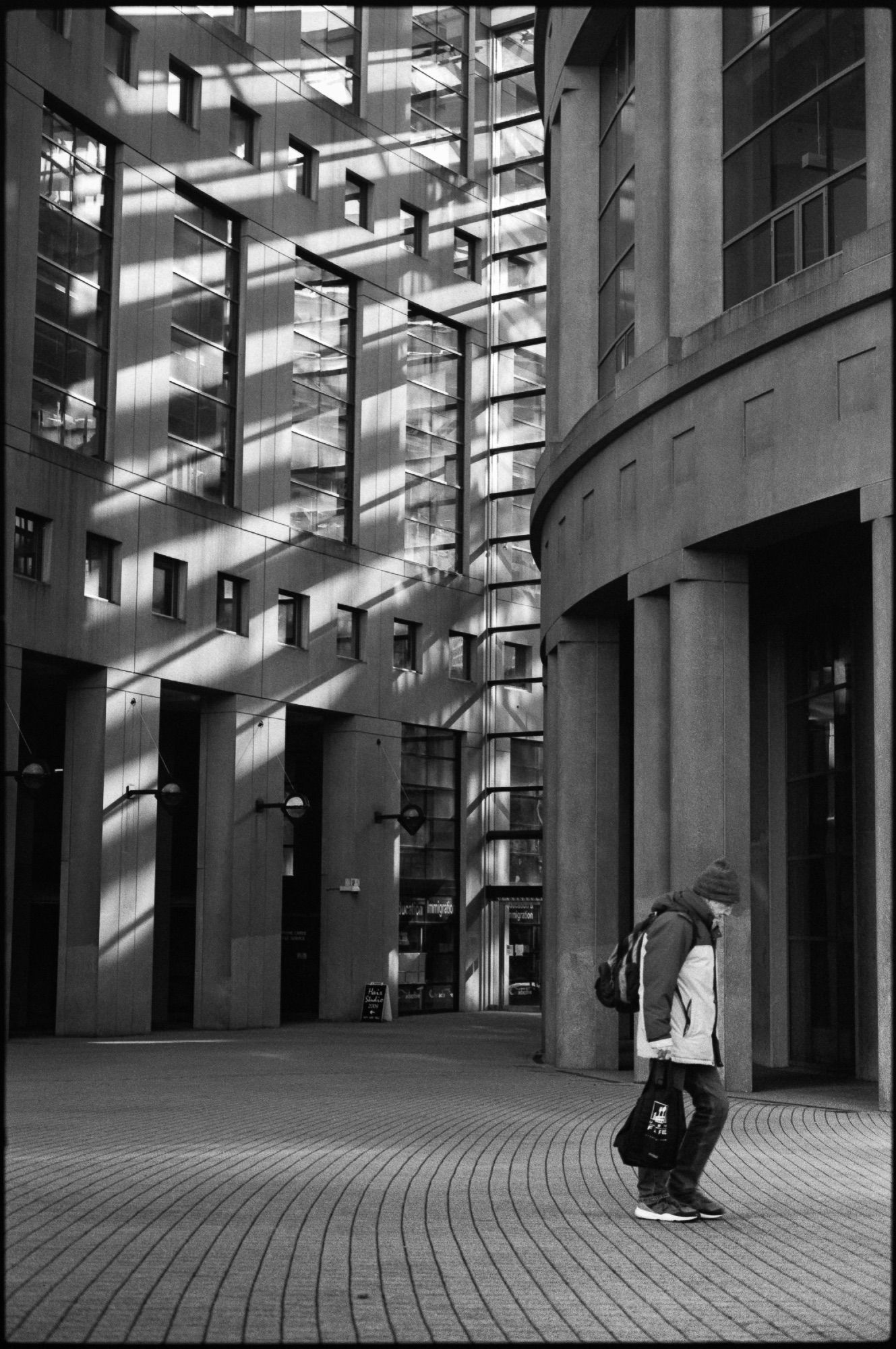 Light glows from the library entrance as a man shuffles past.