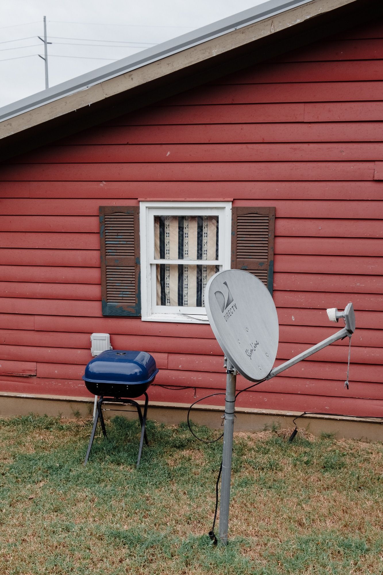 Detail of a bungalow with a barbecue and a satellite dish.