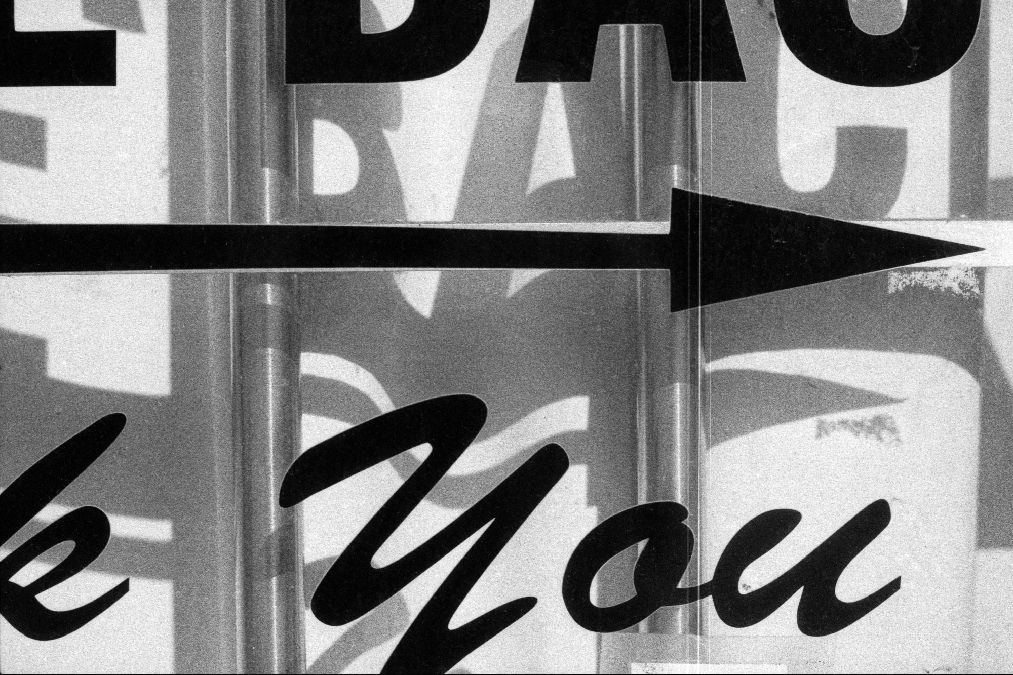 Black and white photographic detail of an arrow and the words “Thank you” in a script typeface.