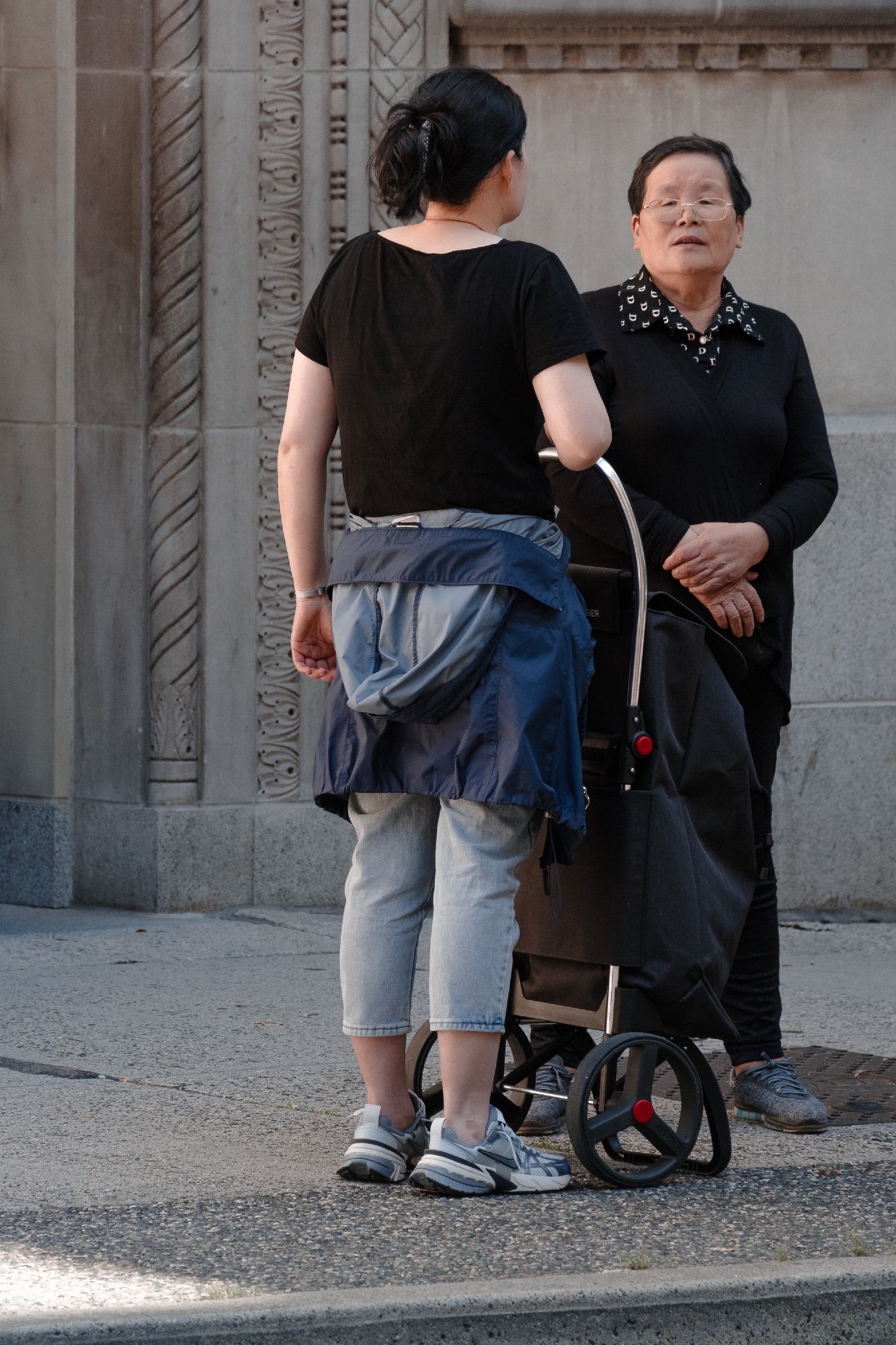 Two individuals stand pensively in pale light.