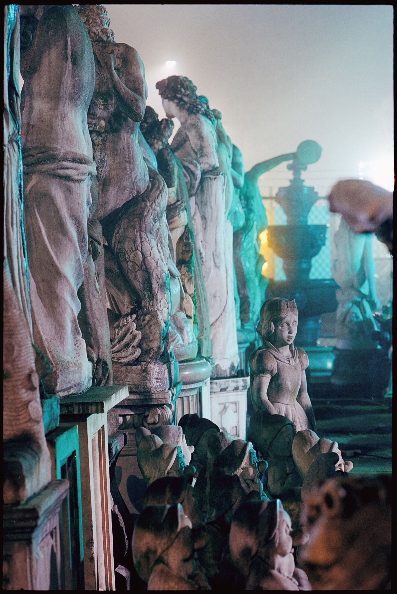 A statue of a small girl looks away from the others.