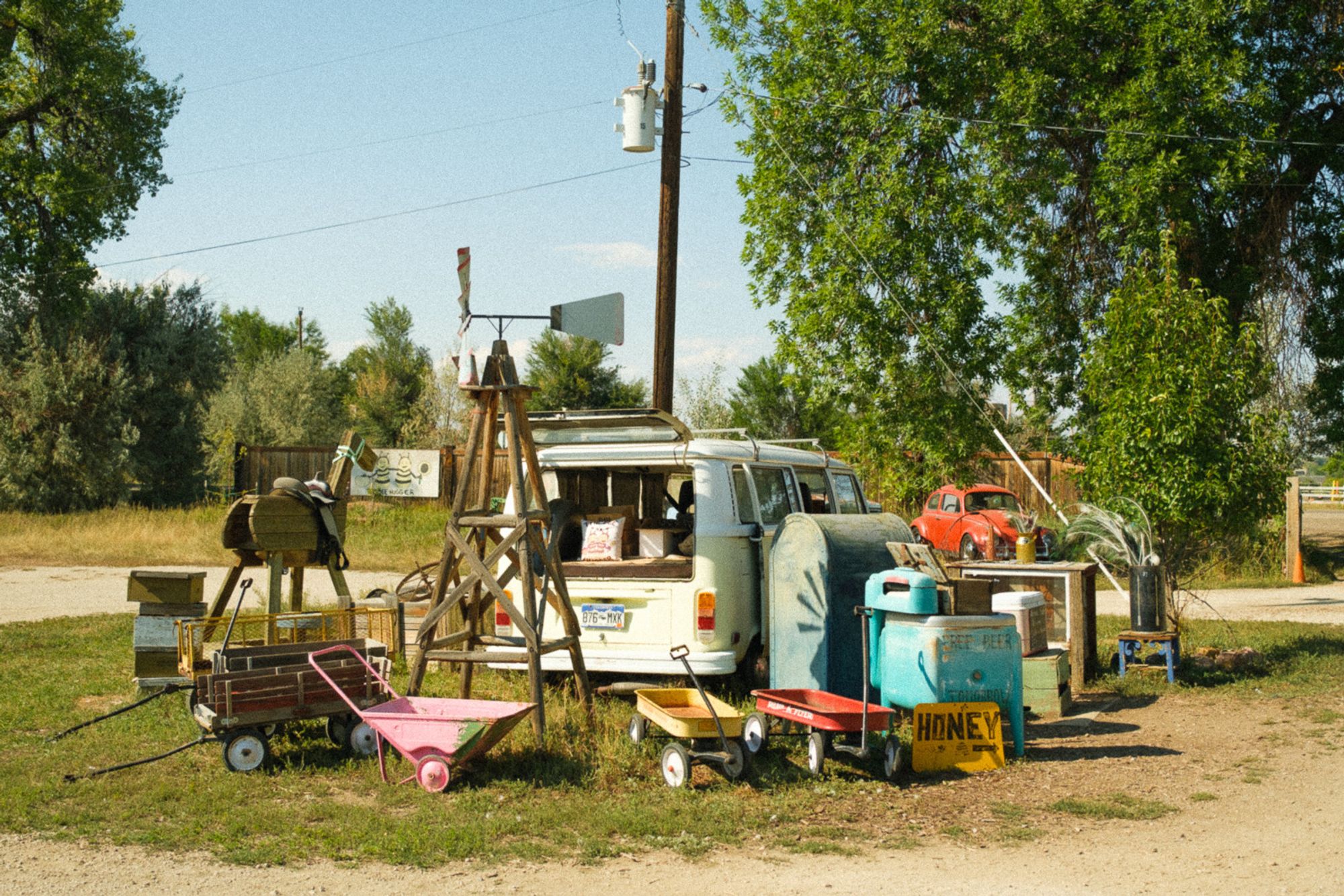 A microbus is surrounded by various farm ephemera.