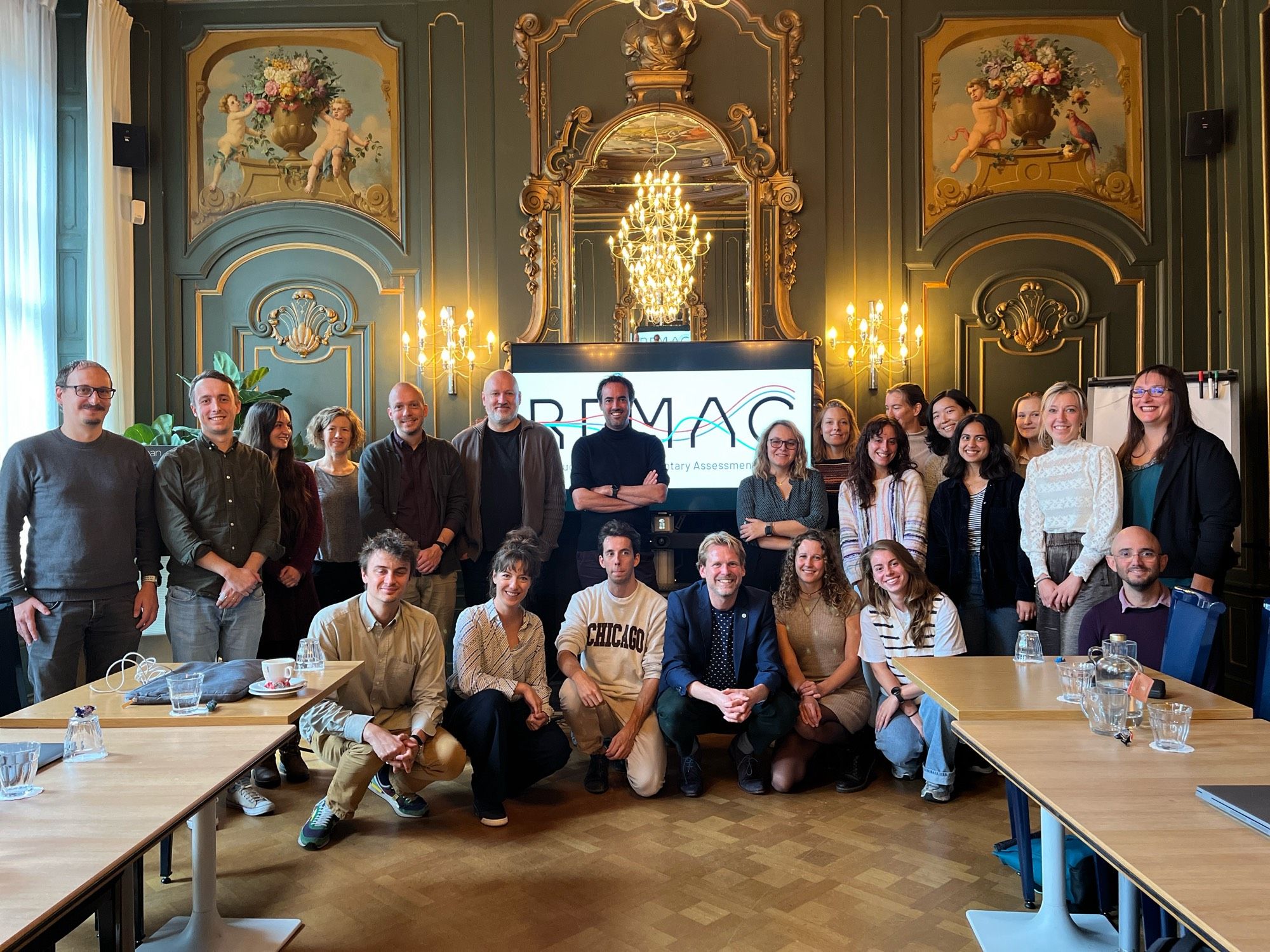 a group of 25 scientists in a group photo in a fancy room