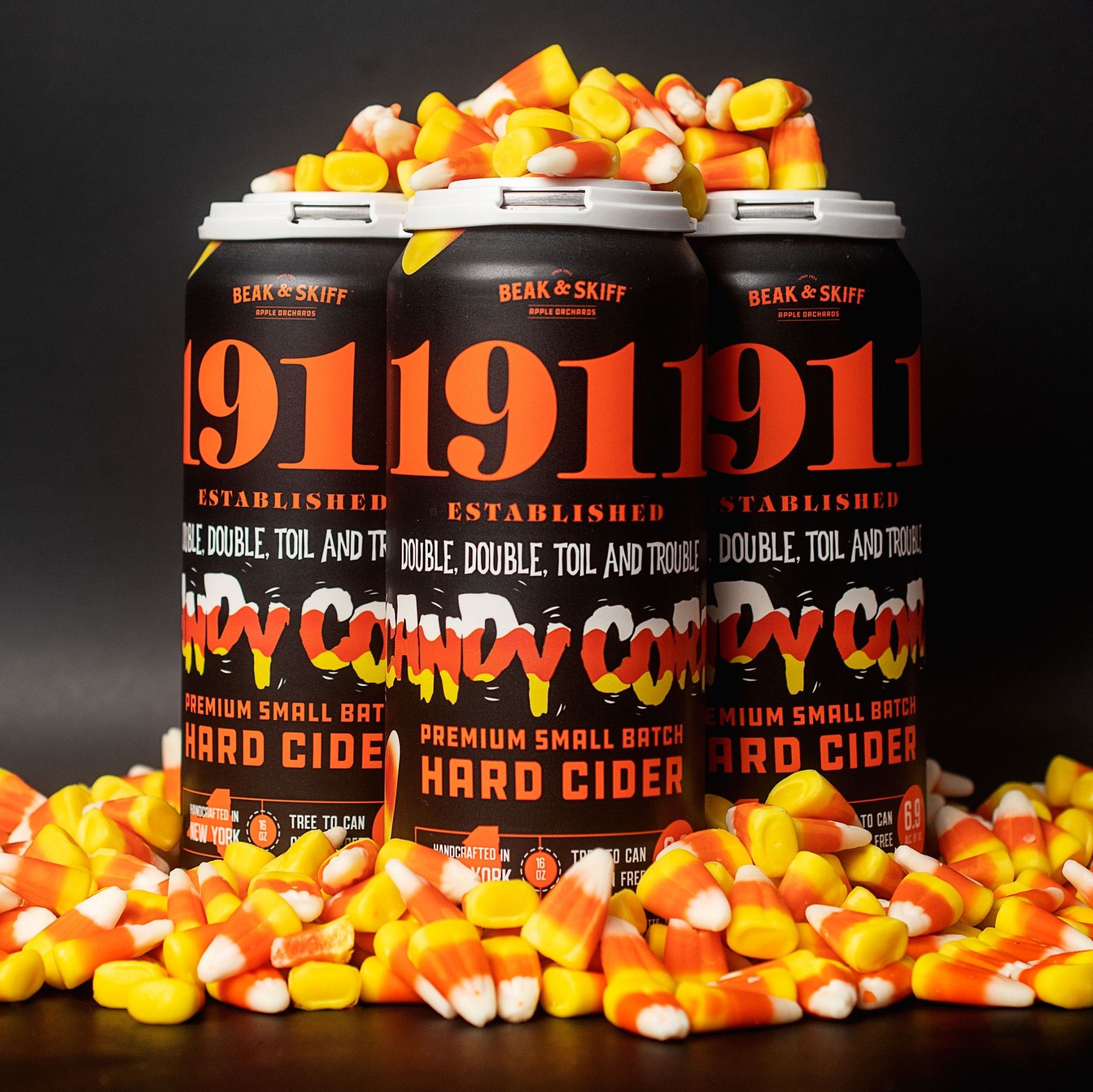 Cans of candy corn hard cider covered in candy corn.