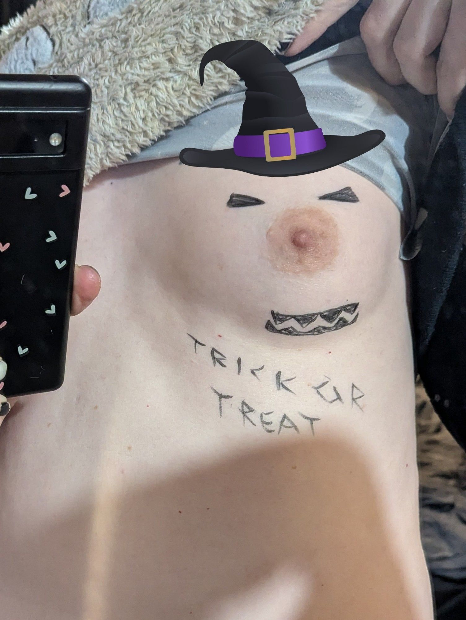 Photo of Callie 's boob with eyes and a mouth drawn onto it and "Trick Or Treat" written under it