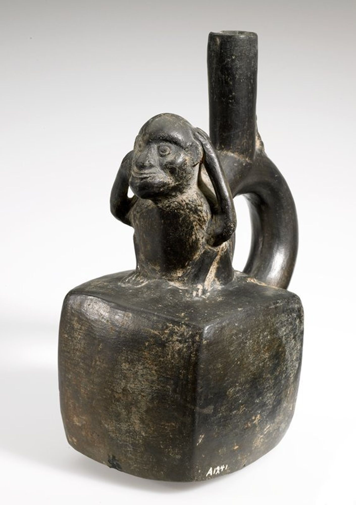 square body; seated monkey on top; stirrup handle extending out from center back of monkey; baby monkey perched on top of handle, clinging to spout; dark brown