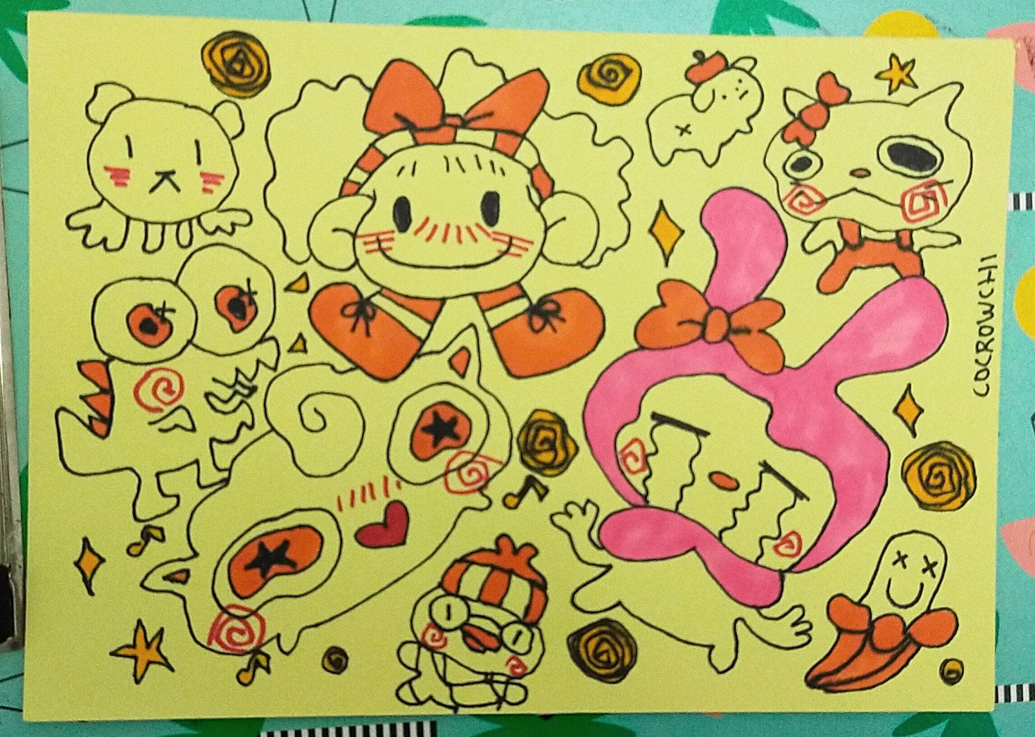 Dibujos varios en cartulina amarilla de distintos personajes como hello Kitty, My Melody y un pato entre otros