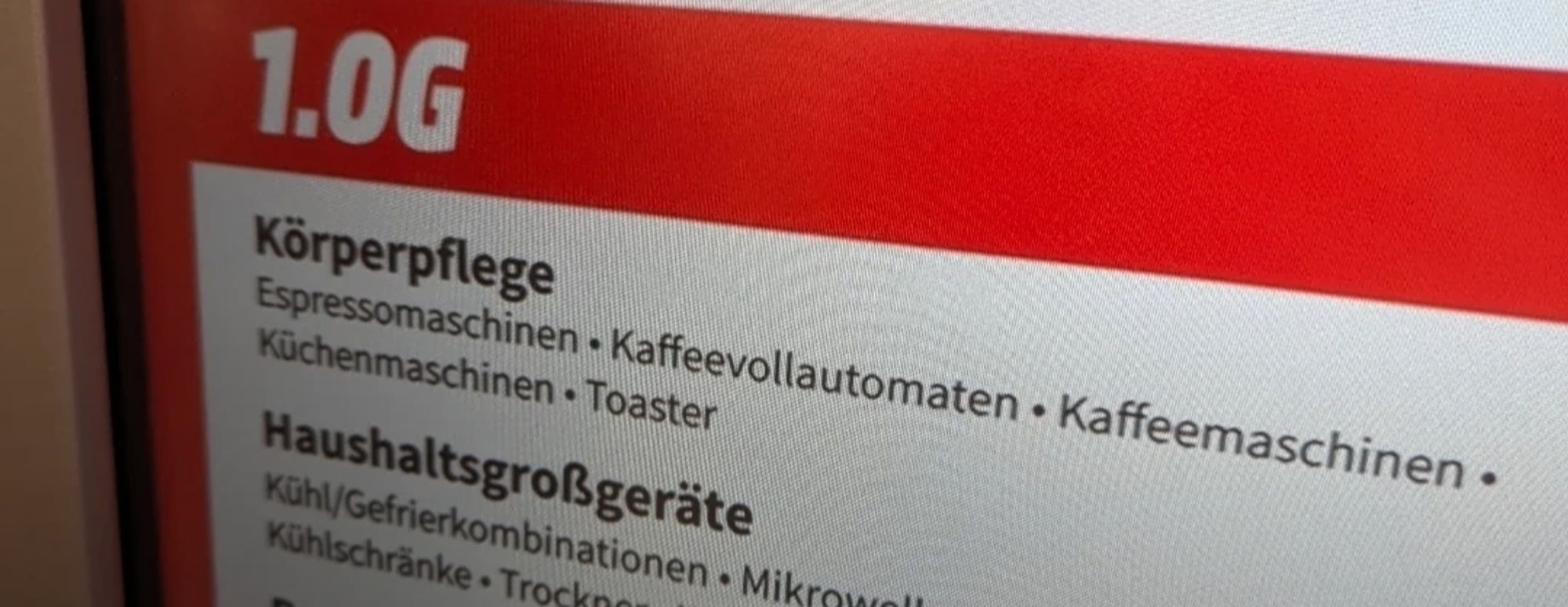 Ausschnitt eines Schildes im Mediamarkt.
1. OG, Körperpflege. Darunter aufgelistet: Espressomaschinen, Kaffeevollautomaten, Küchenmaschinen, Toaster.