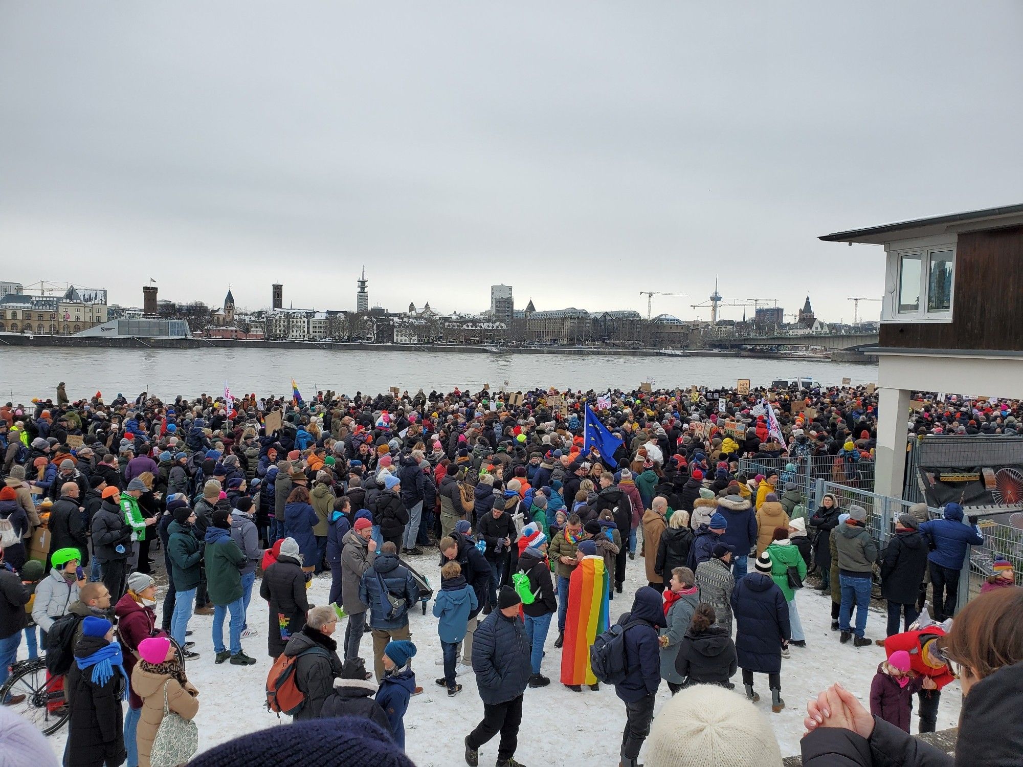 Many demonstrators along the bank of the Rhine, many flags and signs (and colorful hats) visible