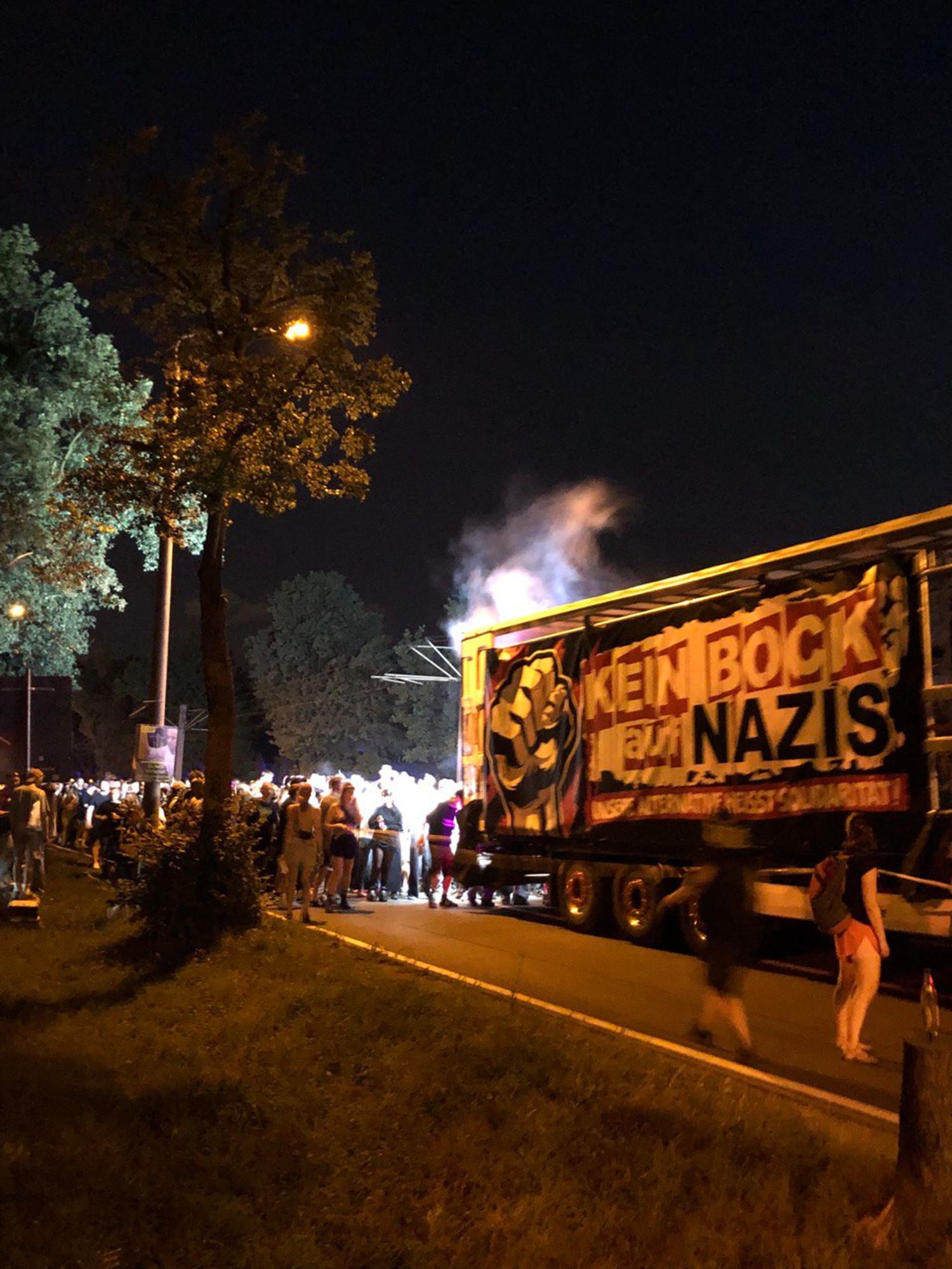 Der LKW mit dem Banner, auf dem steht: Kein Bock auf Nazis führ durch die Nacht in Dresden. hinter dem LKW sind hunderte Menschen