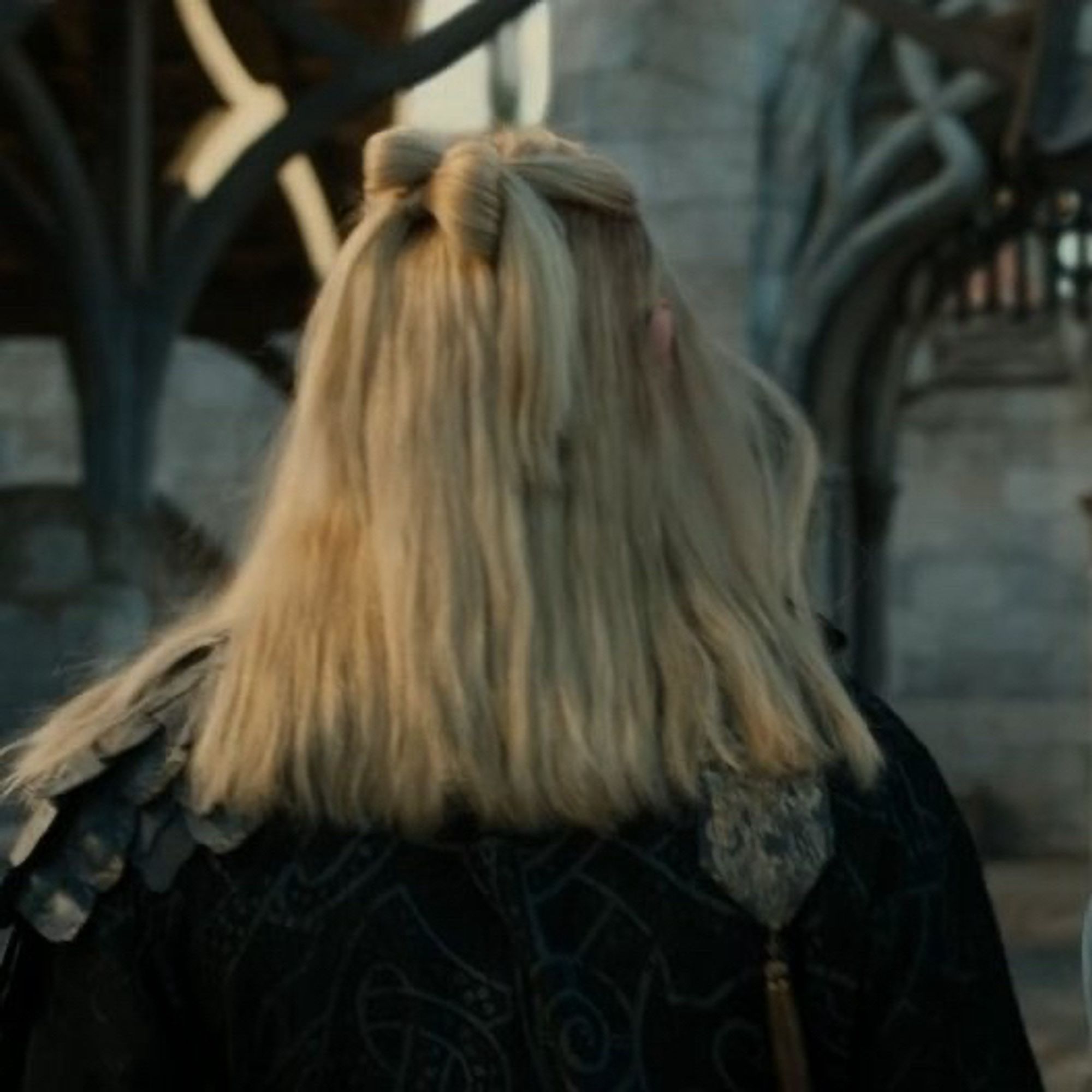 Shot from “The Rings of Power” showing the back of Sauron’s head and his c*nty lil hair bow