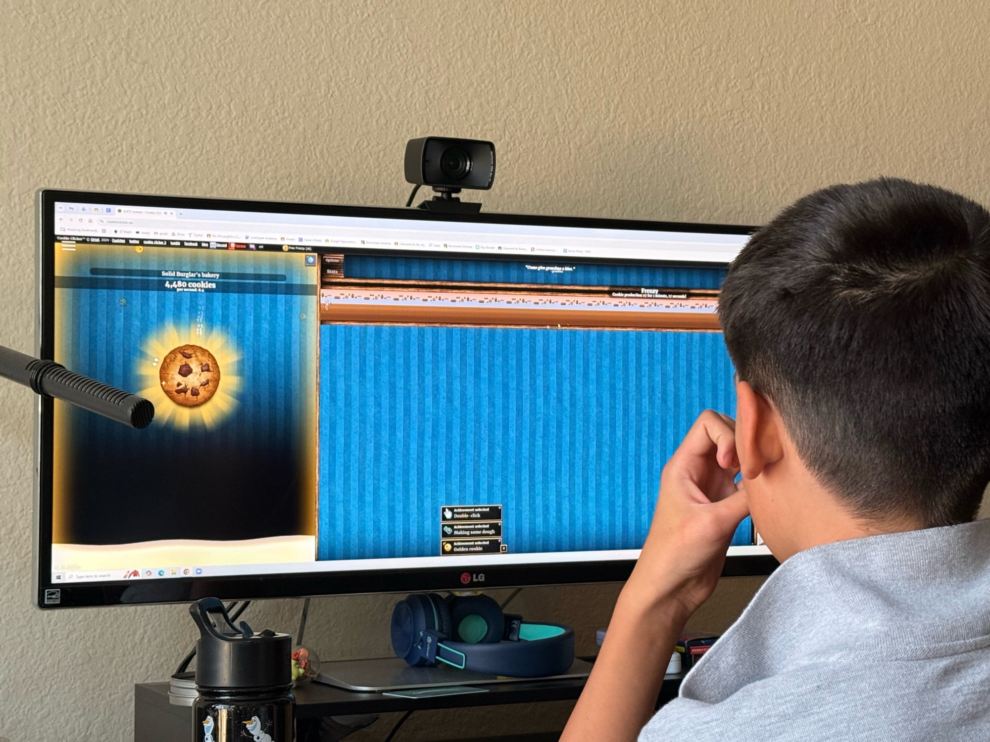 A kid playing cookie clicker for the first time, excited that he found a game that works on his school computers. 