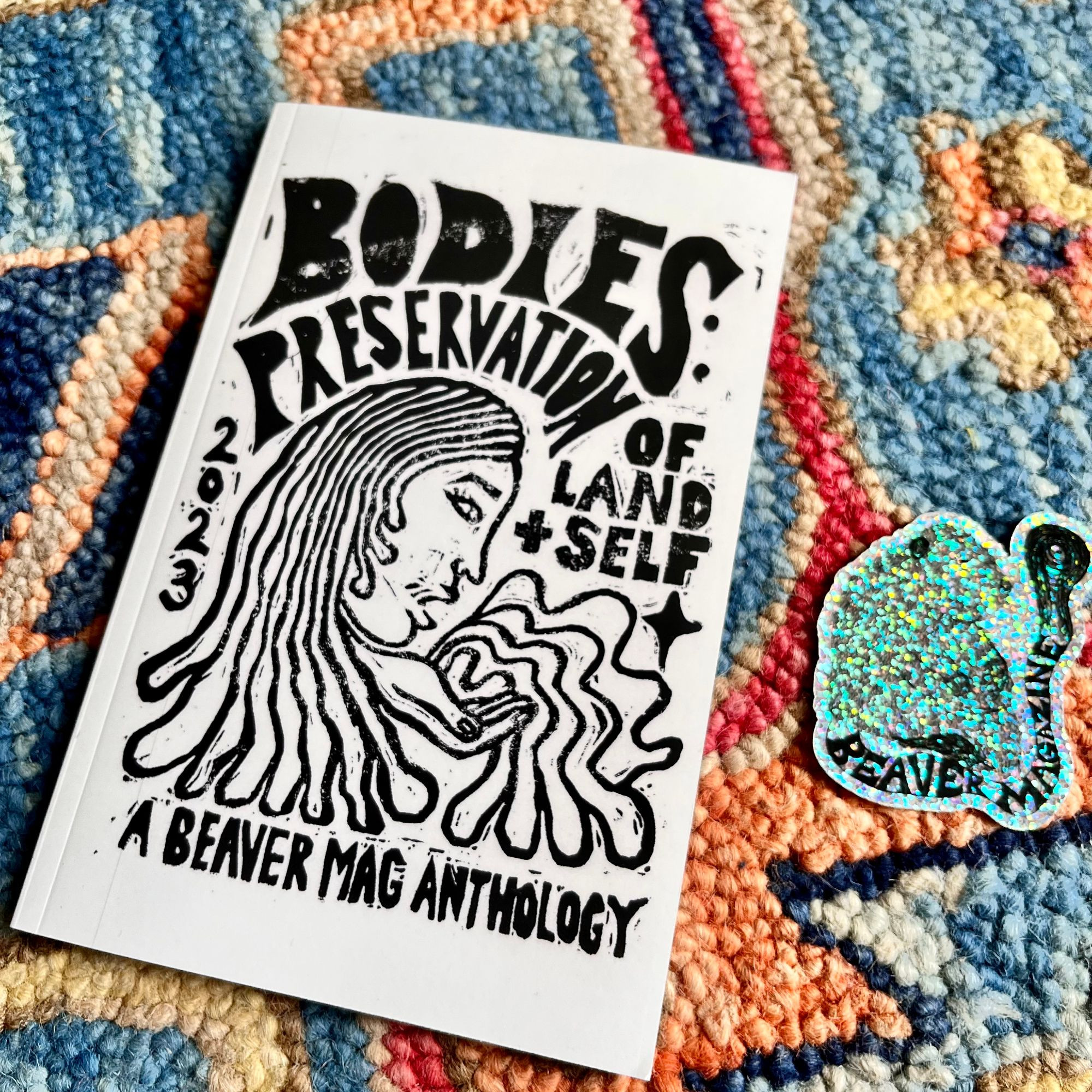 Cover of the BODIES anthology from Beaver Magazine. Black and white, graphics woodcut style illustration of a woman's profile. Hand-written font