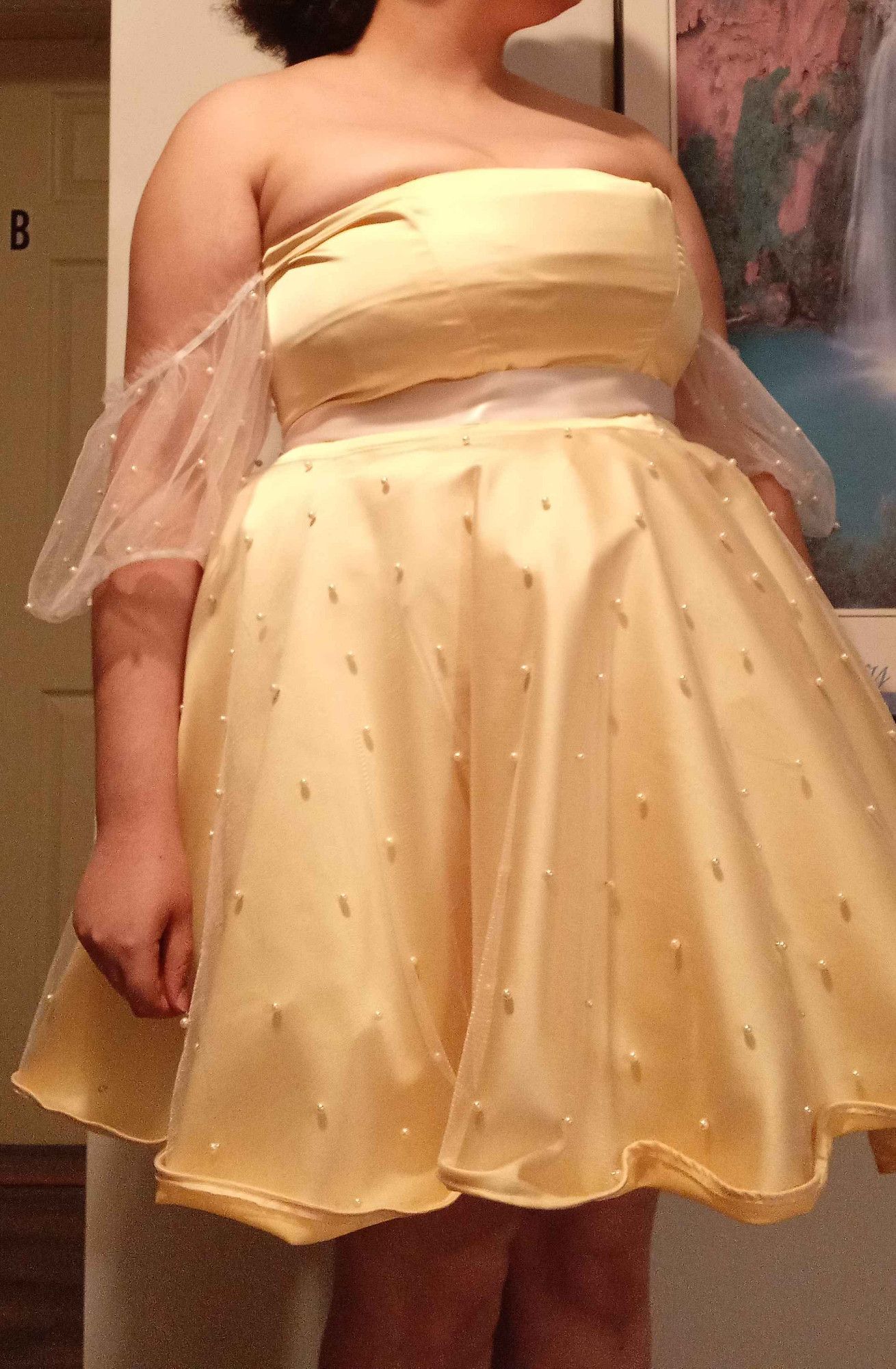 A yellow dress with white pearls