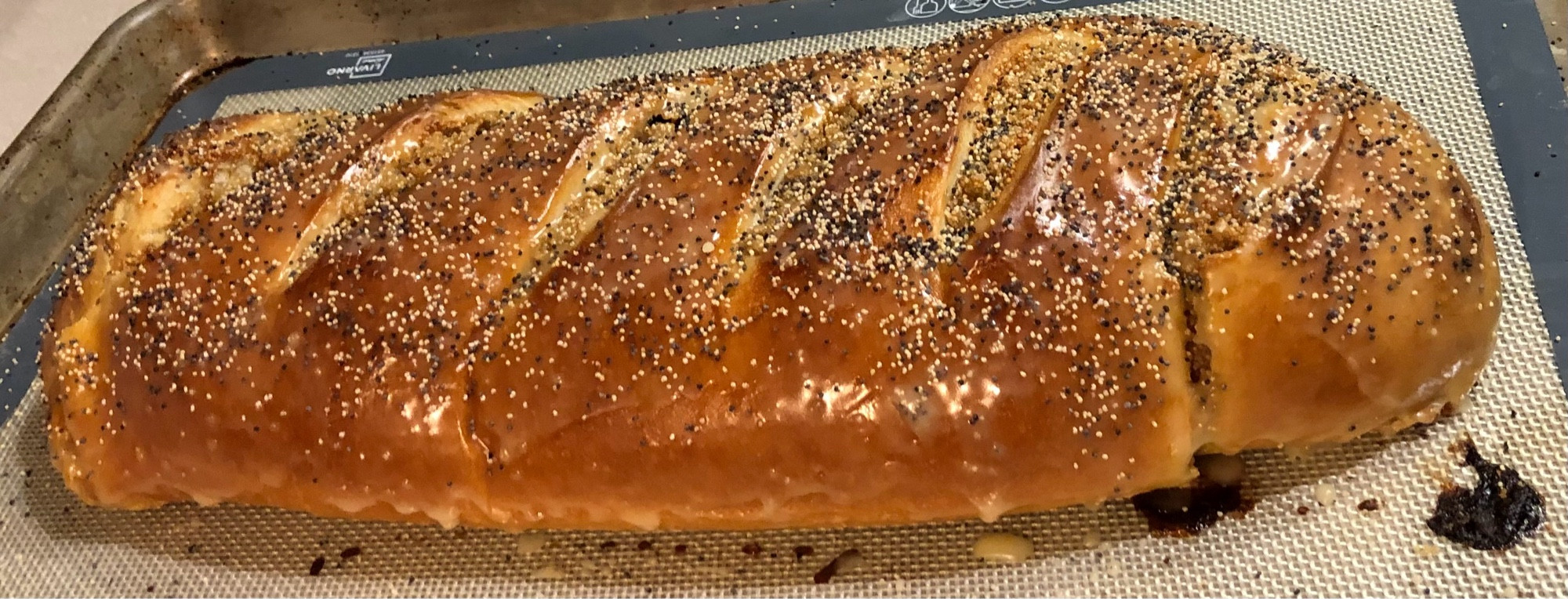 Whole poppyseed roll, glazed and dressed with poppyseeds.