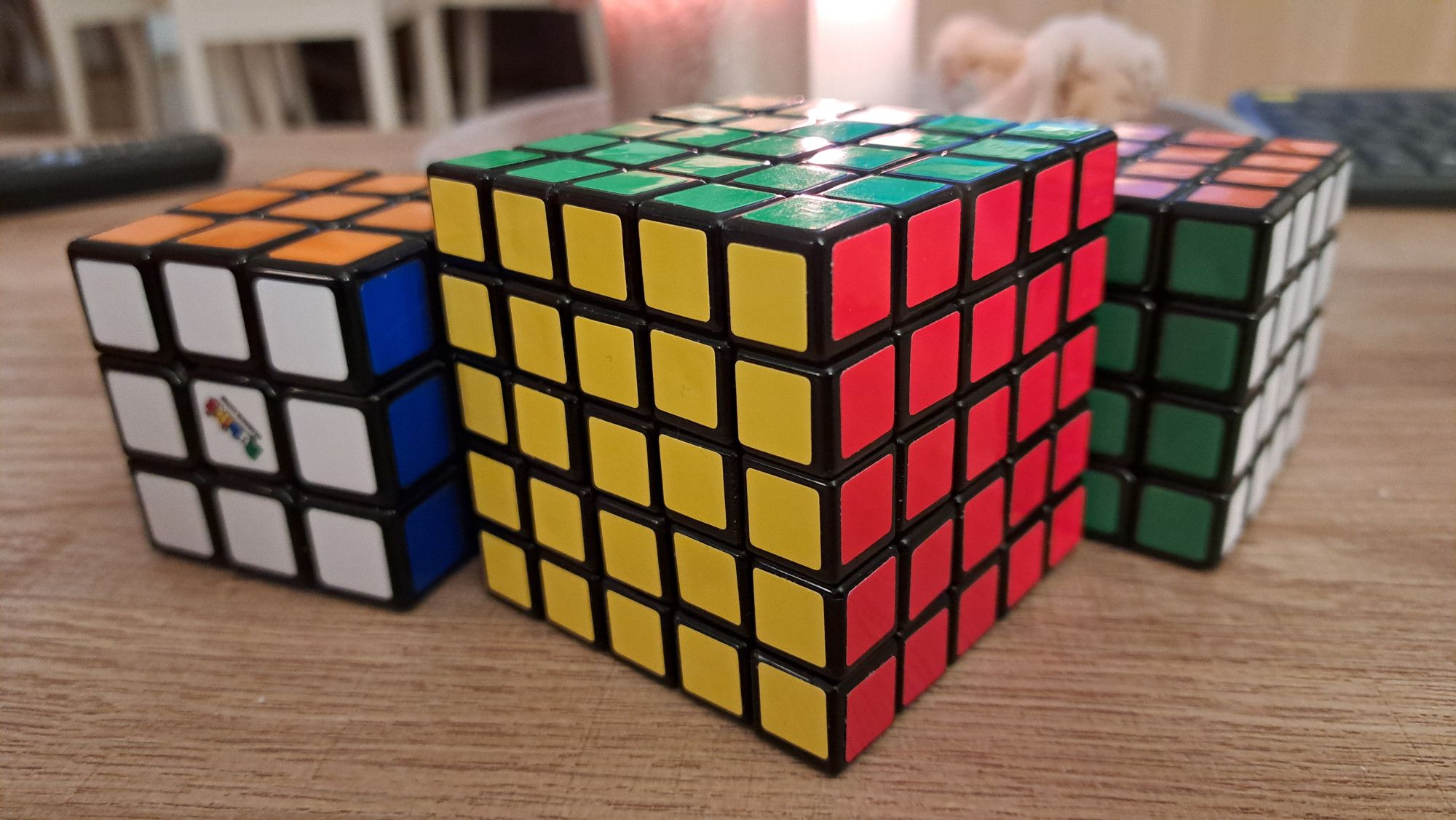 Perinteinen 3×3 sekä kaksi isompaa Rubikin kuutiota.