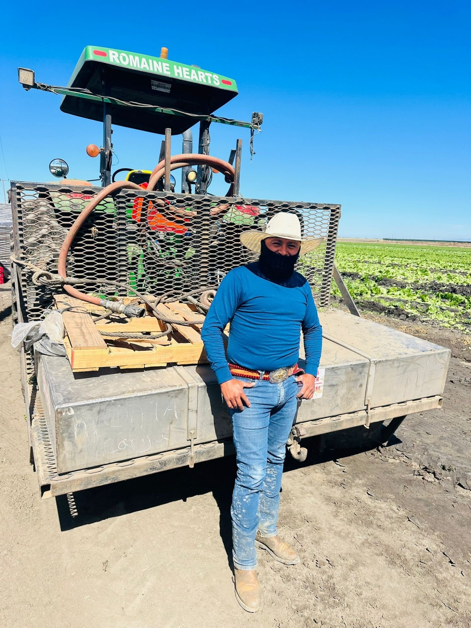 Farm workers standing in front of a trailer at the side of a field as he's beginning a work day