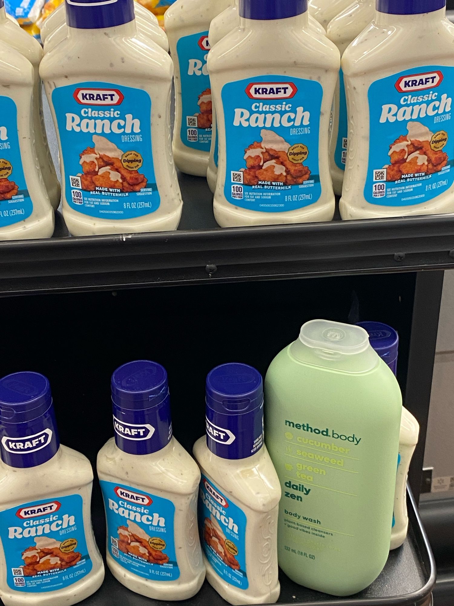 A bottle of body wash that someone put back among a rack of ranch dressing