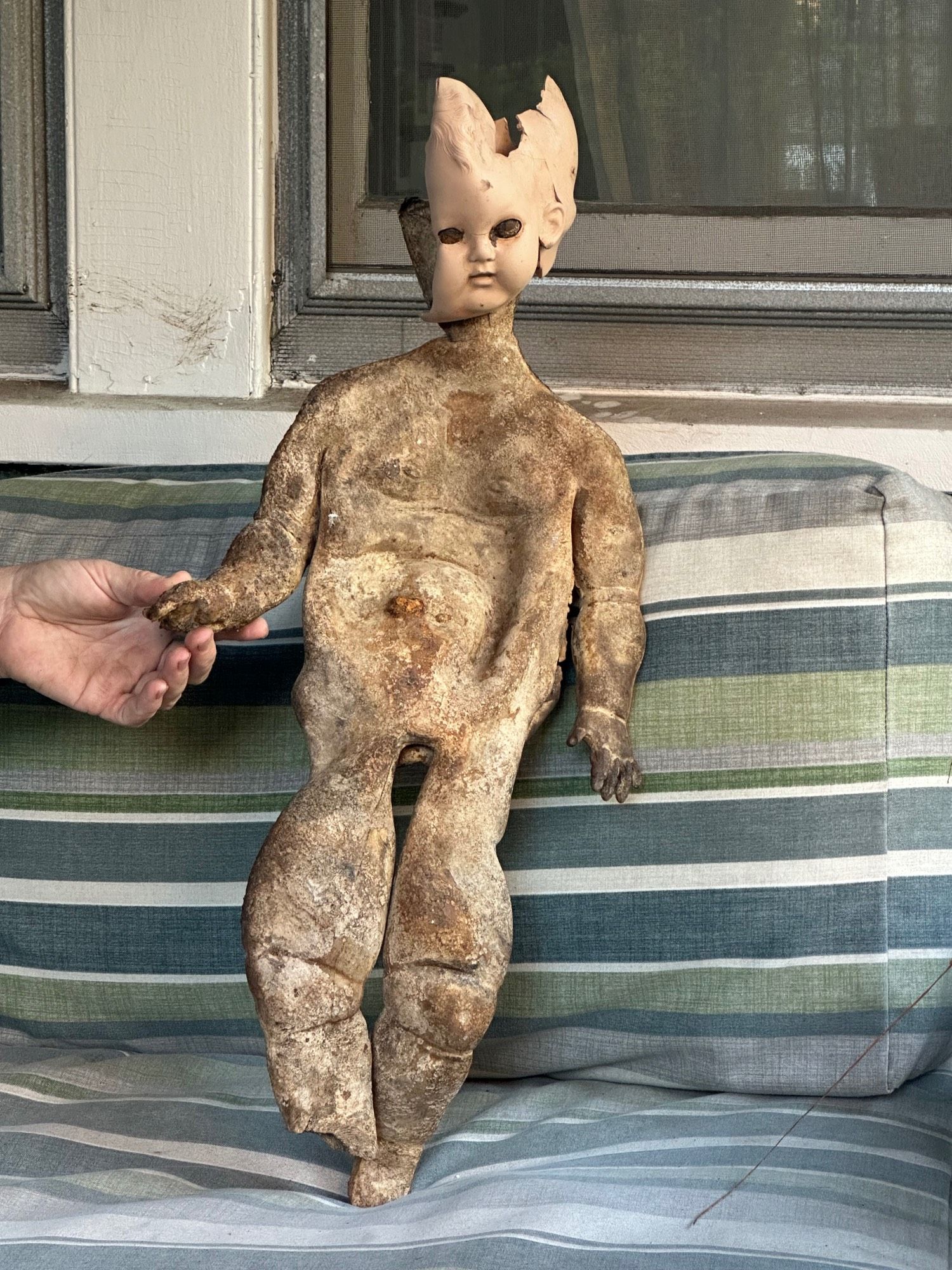 Large awful rotten doll with weird head.