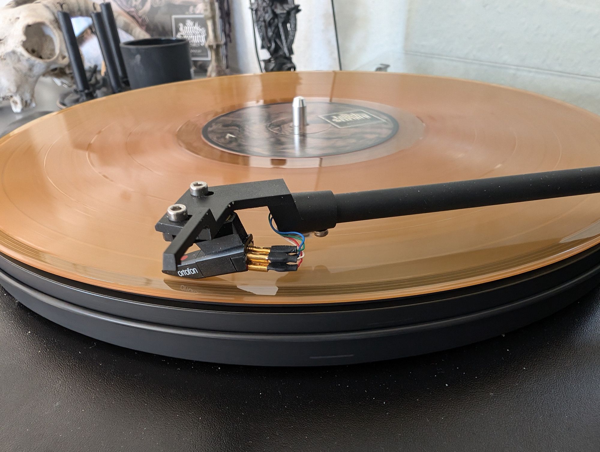 Goldbraunes Vinyl mit aufliegendem Tonarm.