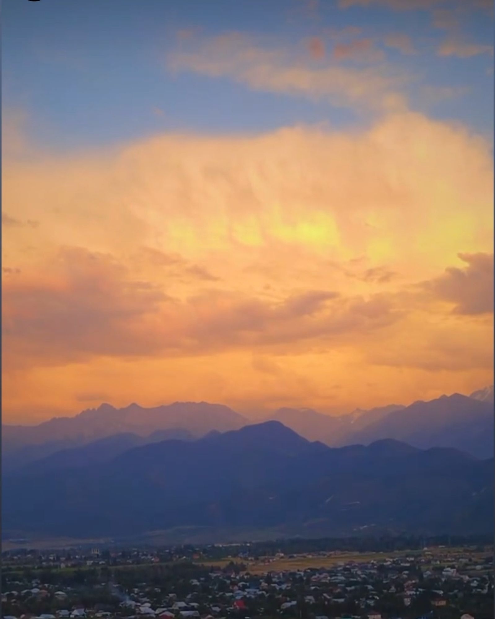 Der Himmel mit Wolken, in den Strahlen der untergehenden Sonne, über den Bergen. Almaty, Kasachstan.