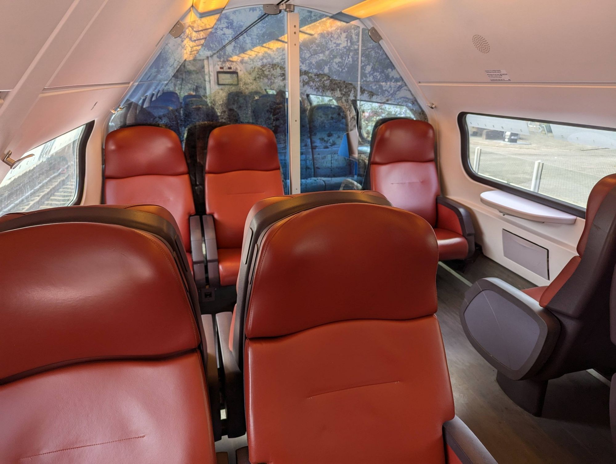 Train interior, upper deck VIRM-4. red first class seats in the foreground and blue seats behind the glass