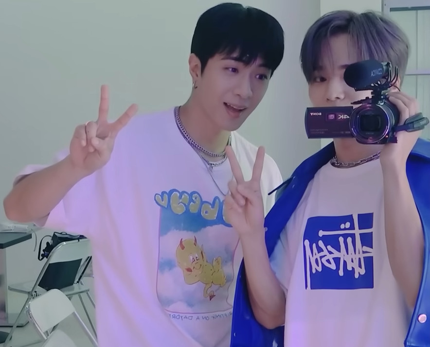 photo of Wyatt and Yuto from ONF giving peace sign, yuto holding camcorder