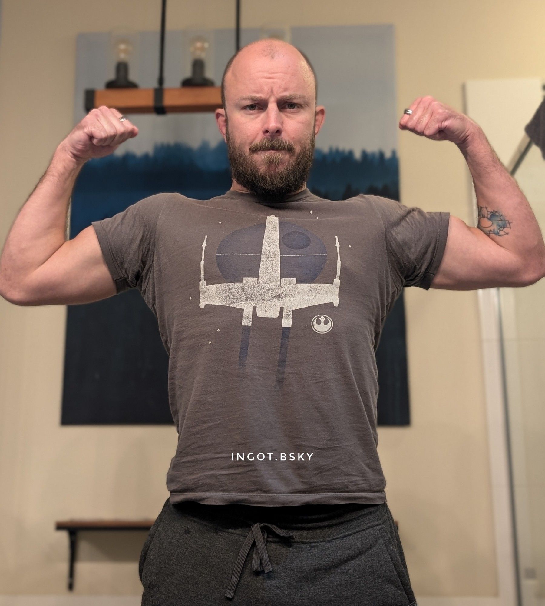 Double bicep flex in a star wars shirt.