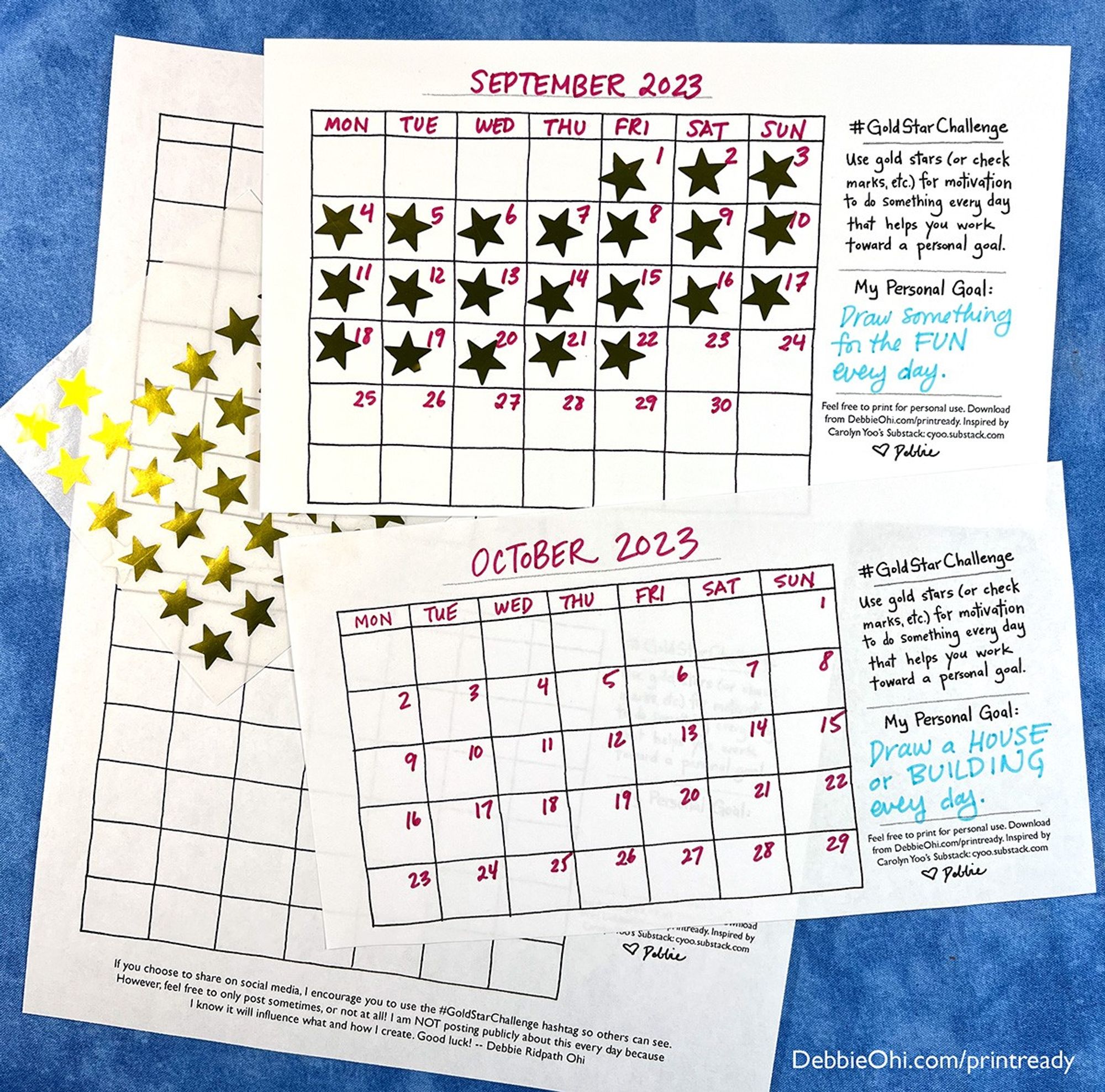 This image shows two printed calendar pages for September and October 2023, filled with gold star stickers. The September calendar is filled with stars on most days, while the October calendar has fewer stars. Each calendar has a personal goal written on the side: "Draw something fun every day" for September and "Draw a house or building every day" for October. Additional blank calendar sheets and a sheet of gold star stickers are also visible in the background. The website URL "DebbieOhi.com/printready" is in the bottom right corner.