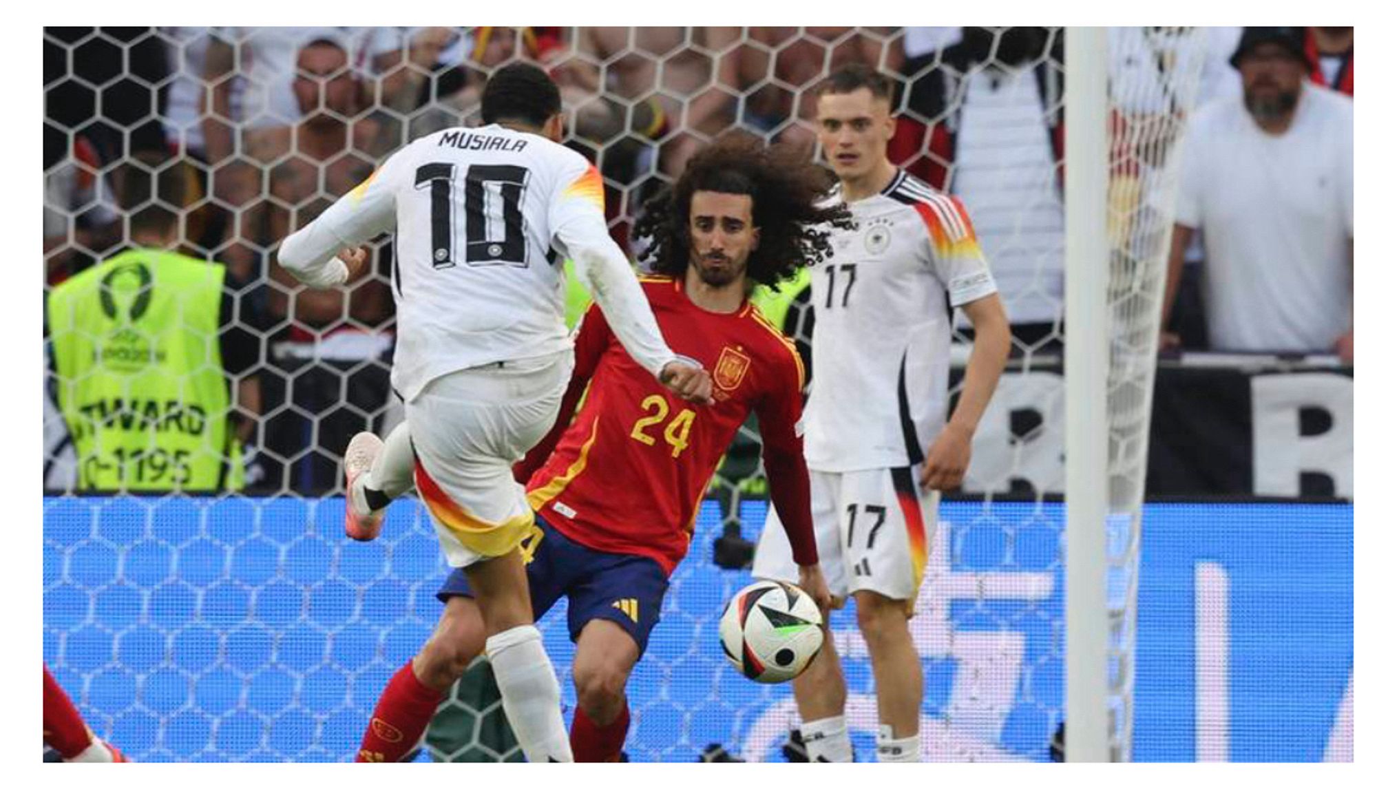 Foto des spanischen Nationalspielers Marc Cucurella, der, ungeahndet, einen Schuss von Jamal Musiala mit dem angespreizten Arm pariert. In spanischen Strafraum.