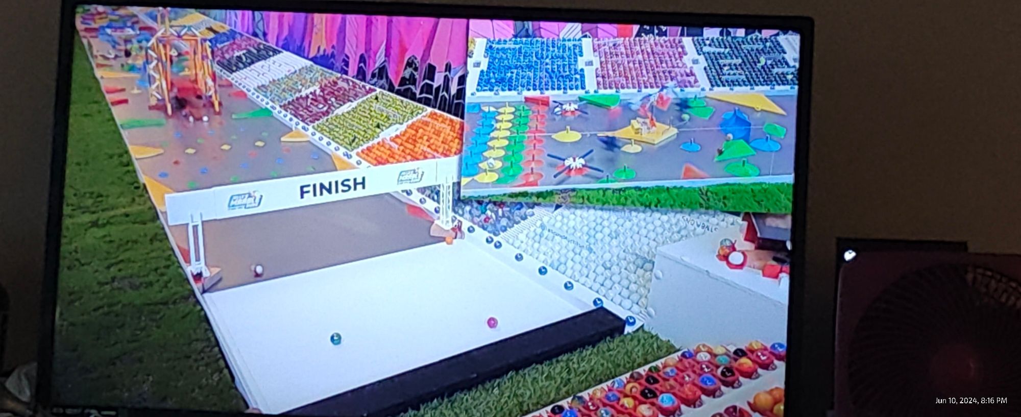 Jelle's Marble Run finish line with a ton of other marbles cheering in the stands. While 3 marbles are either crossing the finish line or have already crossed.