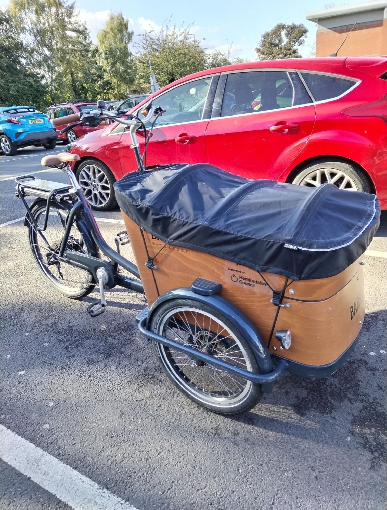 A bike with a large box type carrier on the front. Funny looking thing.