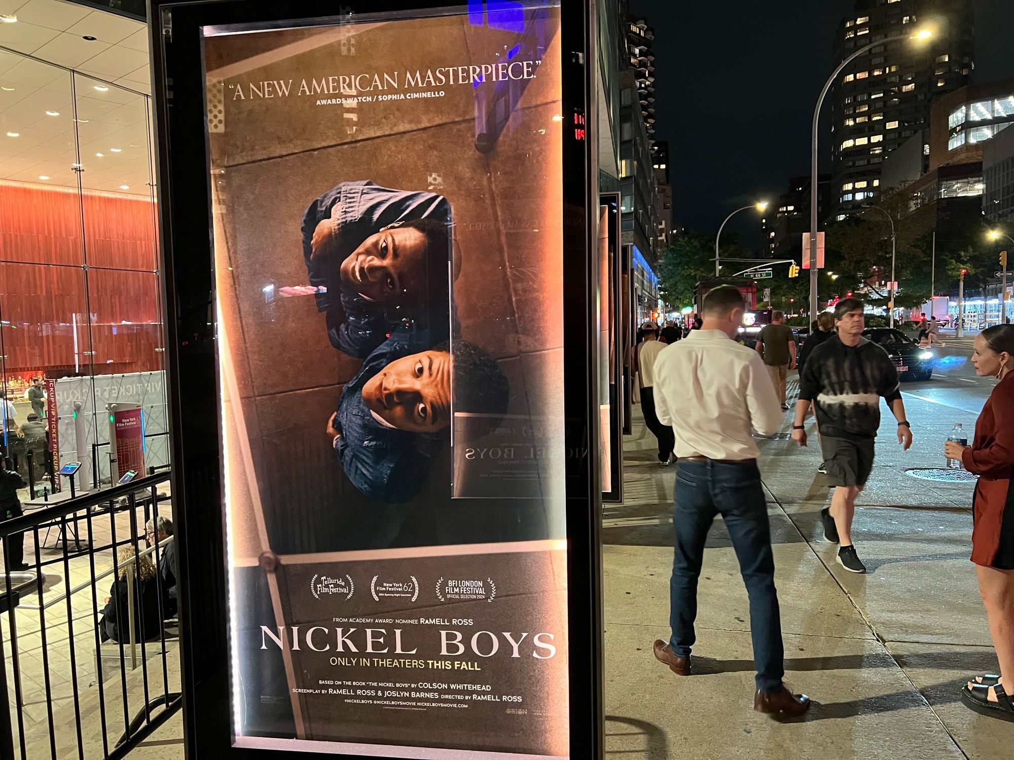 A poster for Nickel Boys, which includes two African American teenagers, one hugging the other, with the backdrop being the Alice Tully Hall and NYC street.