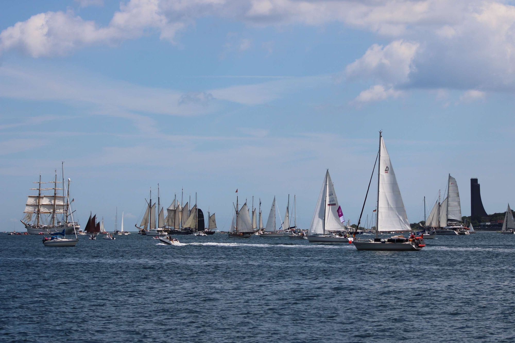 Viele größere und kleine Segelschiffe folgen der Gorch Fock aus der Kieler Förde heraus.