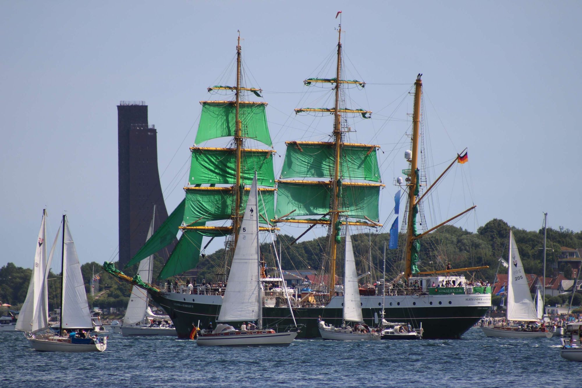 Die Alexander von Humboldt II, Nachfolgeschiff der Alexander von Humboldt, die man aus der Beck's-TV-Werbung kennt, segelt auf der  Windjammerparade 2024 mit einigen kleineren Booten am Marine-Ehrenmal in Laboe vorbei.