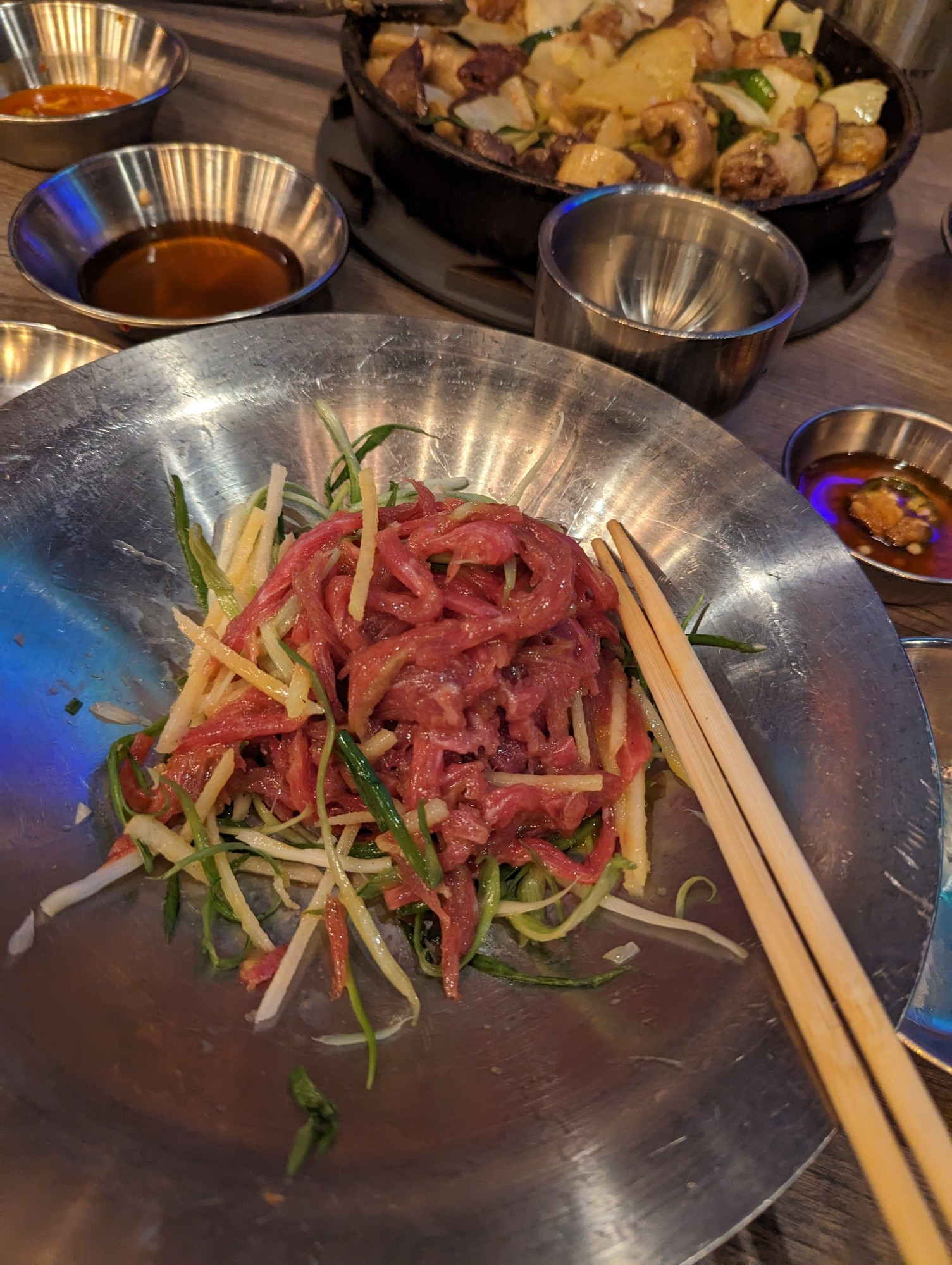 Beef tartar with slivers of pear and scallions mixed with a raw egg yolk.