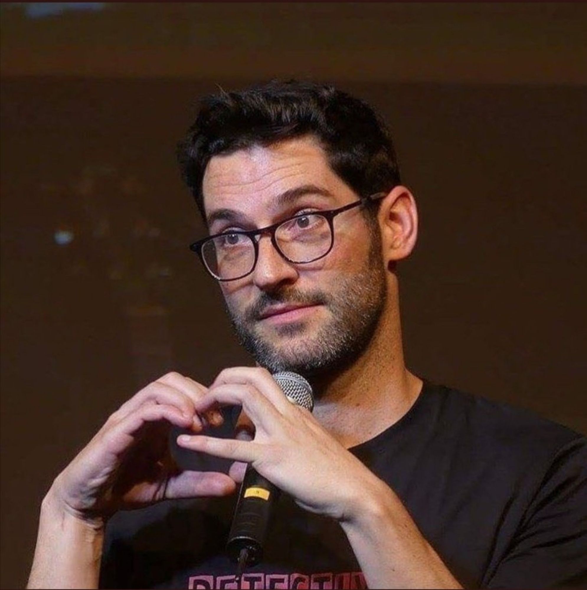 Tom Ellis (as always) at some con; forming a heart to the fans