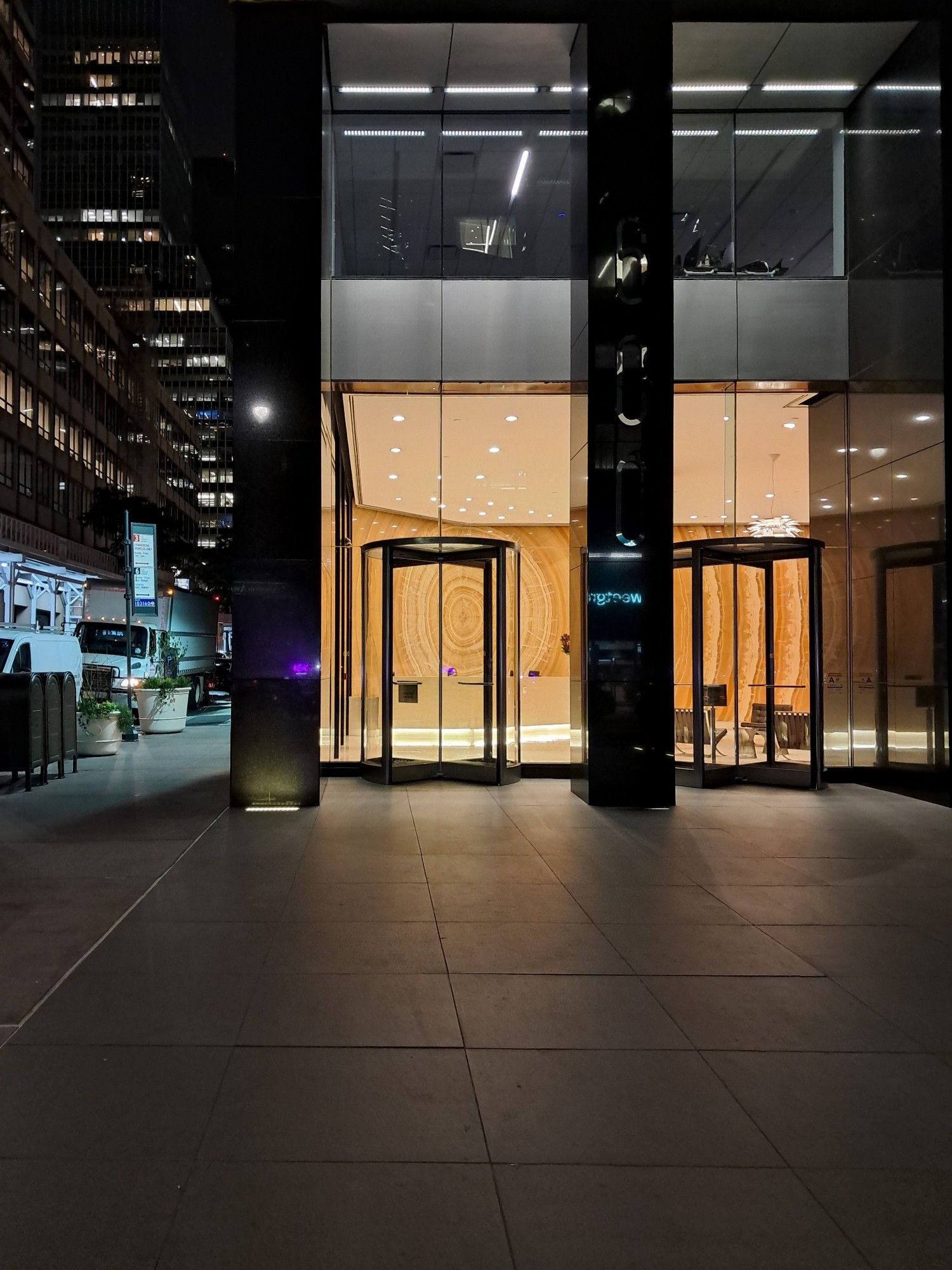 A building lobby glows as seen from the street at night (lexington avenue)