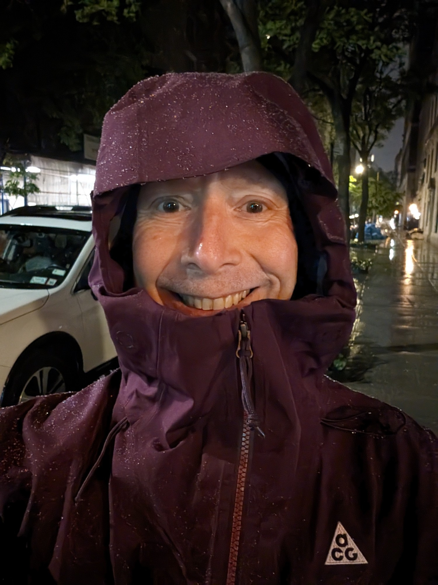 Selfie of me in my maroon Nike ACG rainsuit with the hood up.