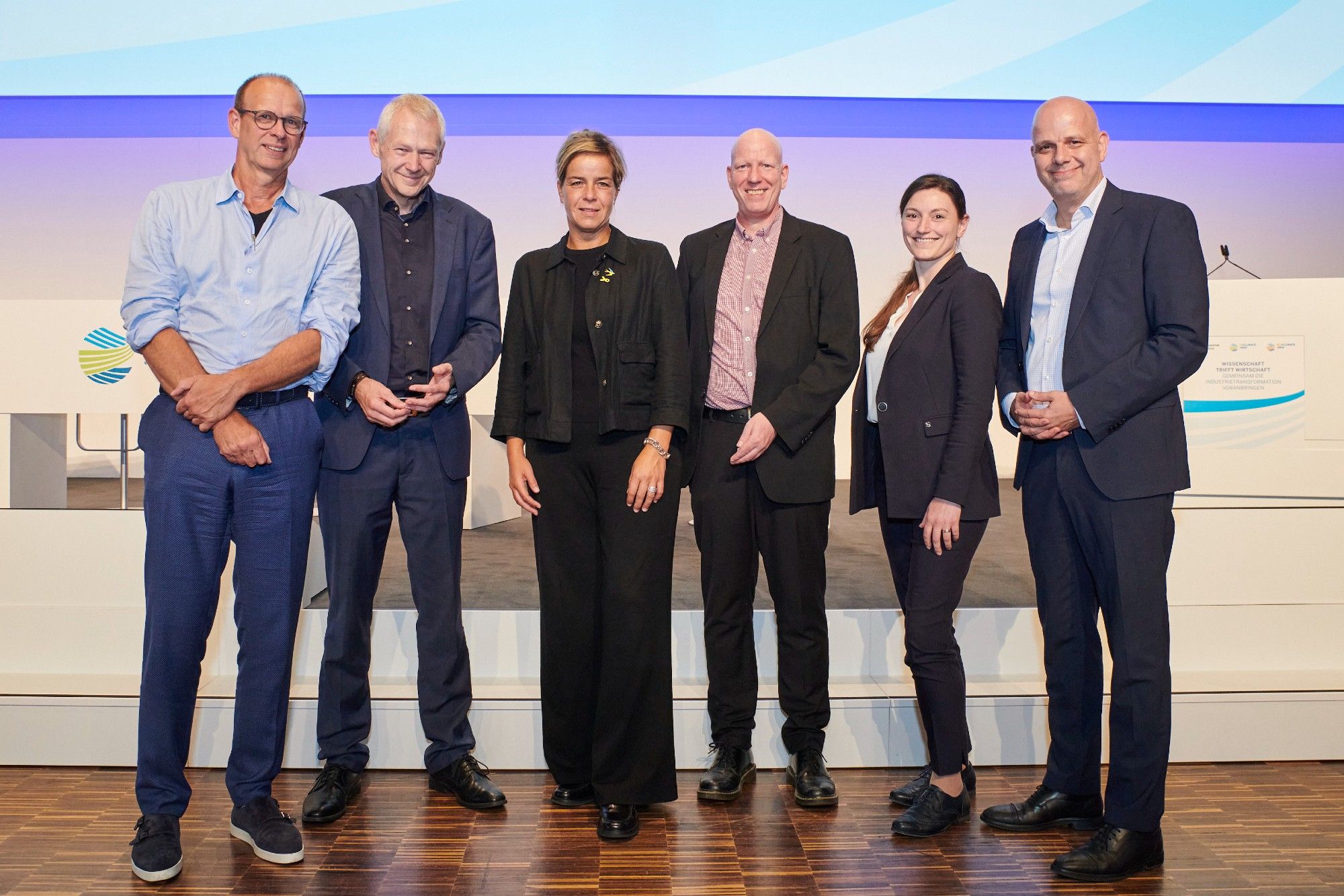 Gruppenfoto. Personen v.l.n.r.: Dr. Christoph Sievering (Wissenschaftlicher Referent Wuppertal Institut), Prof. Dr. Manfred Fischedick (Präsident und wissenschaftlicher Geschäftsführer Wuppertal Institut), Mona Neubaur (Ministerin für Wirtschaft, Industrie, Klimaschutz und Energie des Landes Nordrhein-Westfalen), Dr. Michael Walther (Teamleiter NRW.Energy4Climate), Dr. Iris Rieth-Menze (Teamleiterin NRW.Energy4Climate), Dr. Martin Theuringer (Geschäftsführer Wirtschaftsvereinigung Stahl). Quelle: NRW.Energy4Climate