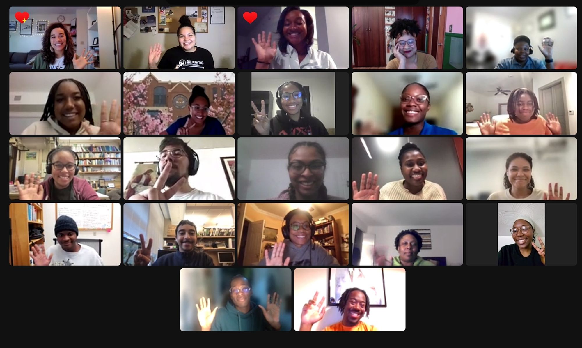 Screenshot of zoom call in 4 x 5 grid showing Black people smiling and waving. Two people showing heart reactions from zoom