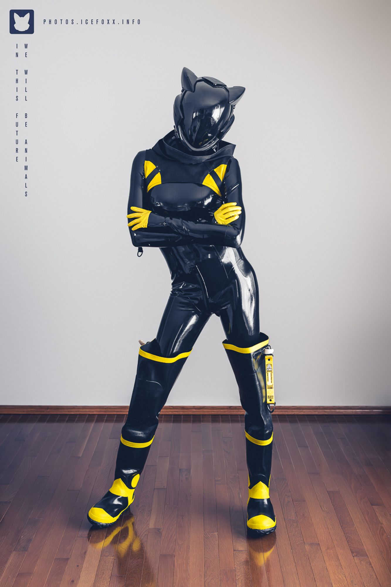 A photo of me wearing a black latex catsuit, black and yellow firefighter waders, a black and yellow cowl, yellow latex gloves, and a black Evangelion style helmet.