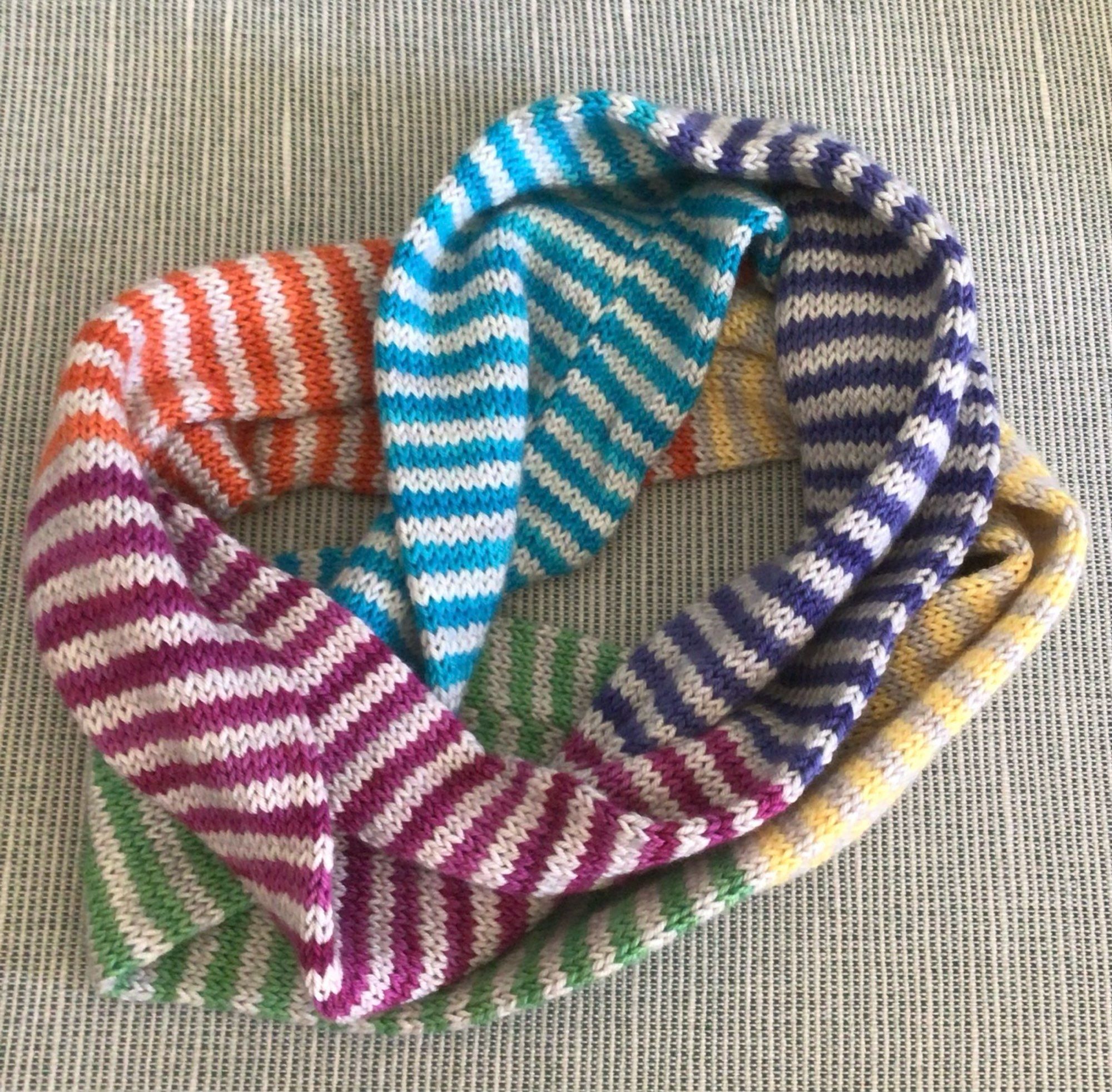 Infinity scarf knit in alternating stripes of gray and rainbow colors