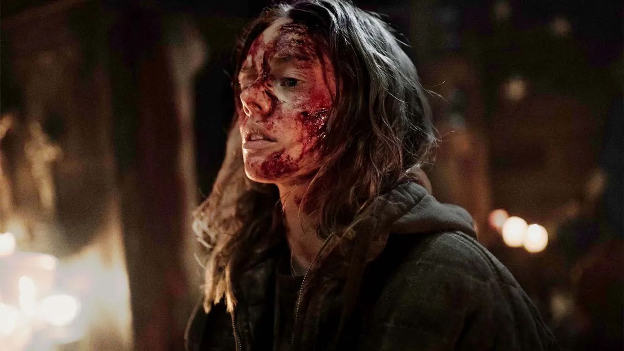 Azrael (Samara Weaving), a young mute woman covered in blood, pants in the middle of a raging fire destroying a cult's camp