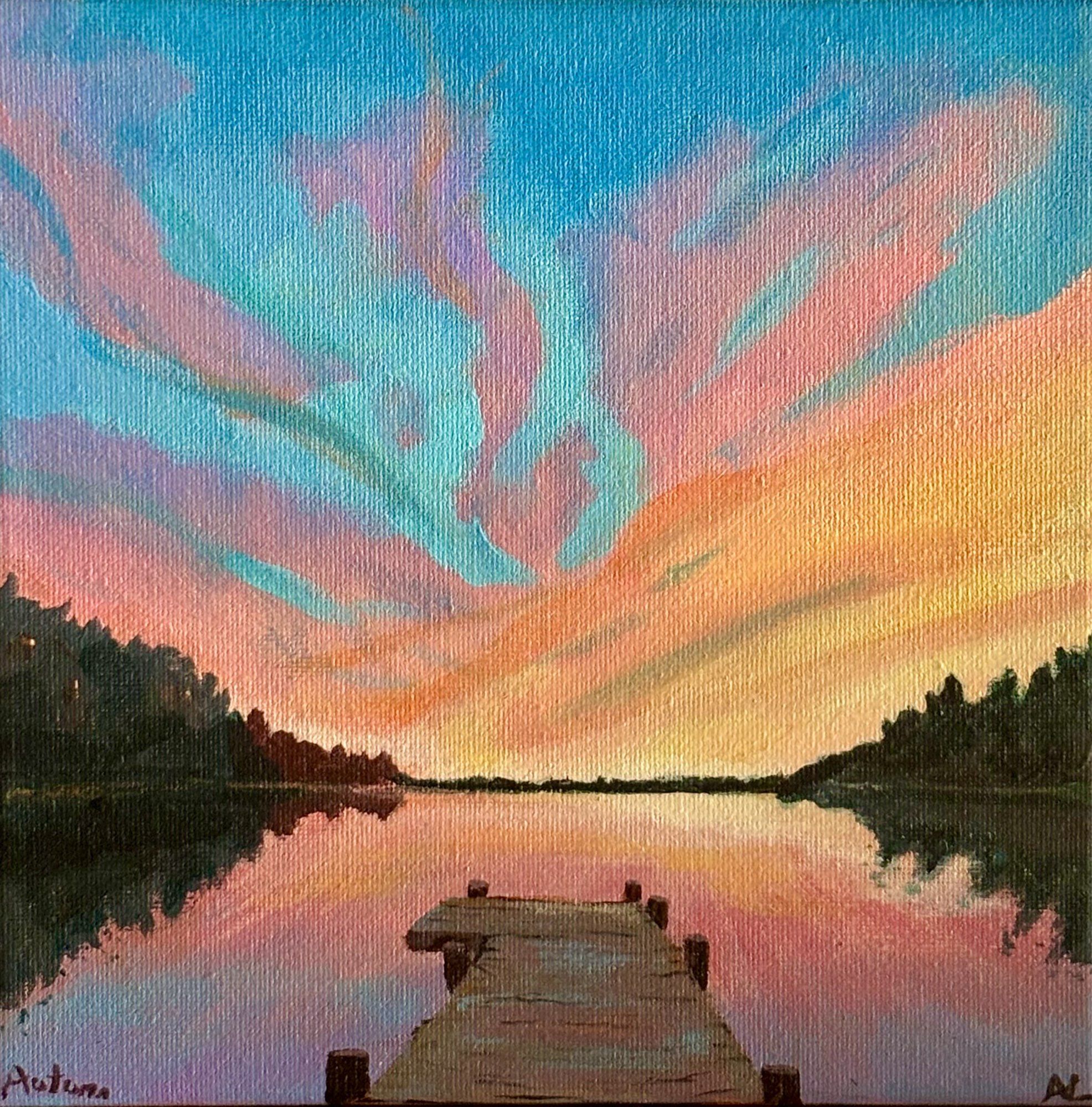 A summer sunset over a lake with an in inviting dock in the foreground.