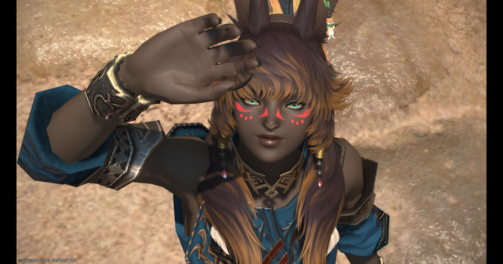 My FFXIV viera, she has brown skin, brown hair with a lighter shade of brown for highlights, looking up and either waving or going to cover her eyes from the sun idk, I don't remember. She has bright green eyes and red face paint. She's wearing a blue shirt with gold and red accents.