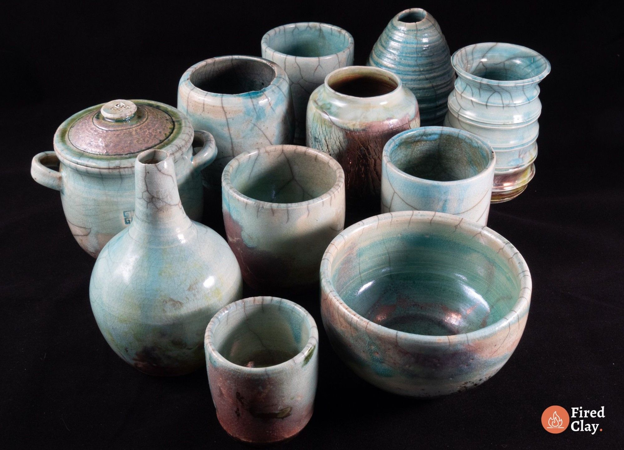 the image shows a collection of 11 raku fired ceramic jars, cups and vases and other vessels. the colours of all of them are blue-green-copper