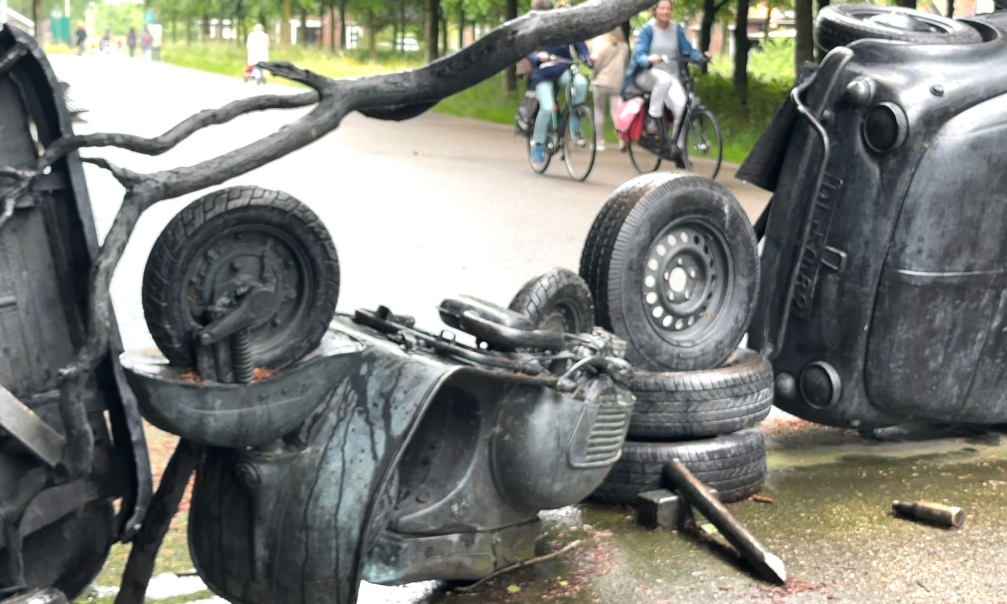 Barricade (2009) in Maximapark, Utrecht with people biking past it.